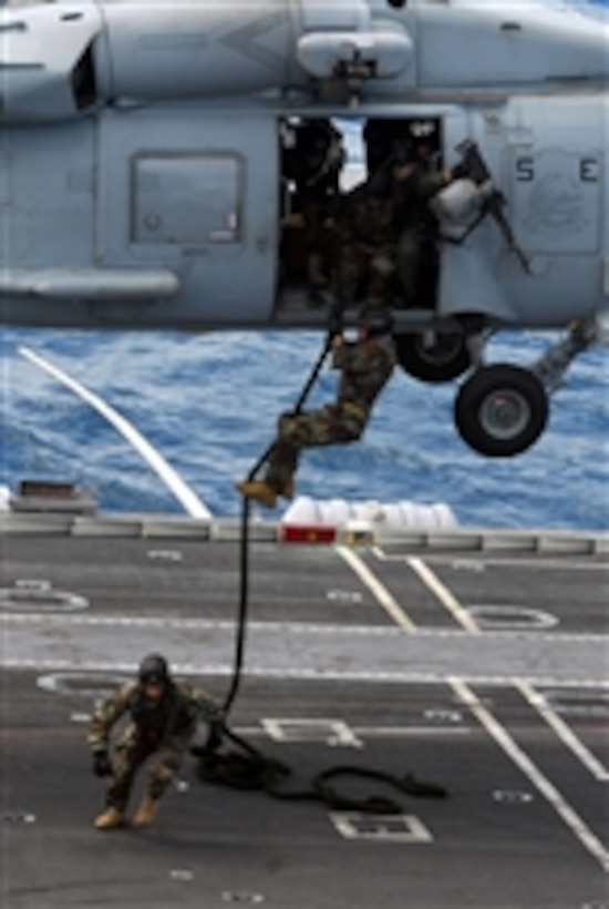 Sailors assigned to Explosive Ordnance Disposal Mobile Unit 5 participate in a fast rope exercise aboard the aircraft carrier USS George Washington (CVN 73) underway in the Indian Ocean on July 7, 2011.  The George Washington began its latest patrol on June 12, departing its forward-operating base at Commander, Fleet Activities Yokosuka.  