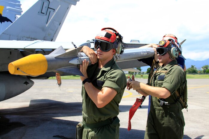Lance Cpl. Nathan Durazo and Lance Cpl. Seth Rickard, ordnance technicians with Marine All-Weather Fighter Attack Squadron 242, unload ordnance from an F/A-18D Hornet jet here Monday. Maintainence crew worked hard to meet the squadron's demanding flight schedule for the day.