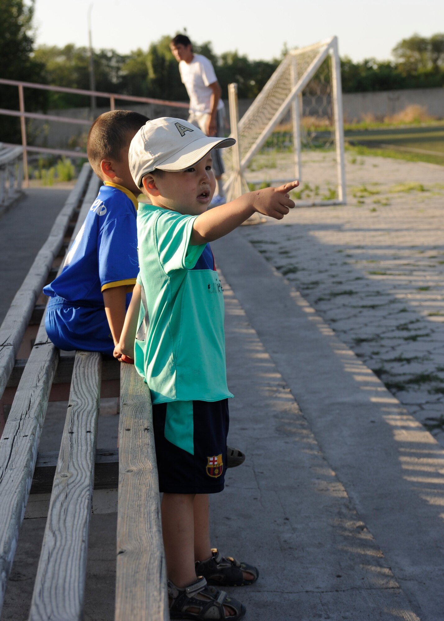 Two children watch the Kyrgyz Soccer Federation staff and Airmen from the Transit Center at Manas play a soccer game in Bishkek, Kyrgyzstan, July 9. Players from the Kyrgyz Soccer Federation staff narrowly defeated the Transit Center team with a 5-4 victory. (U.S. Air Force photo/Tech. Sgt. Tammie Moore)