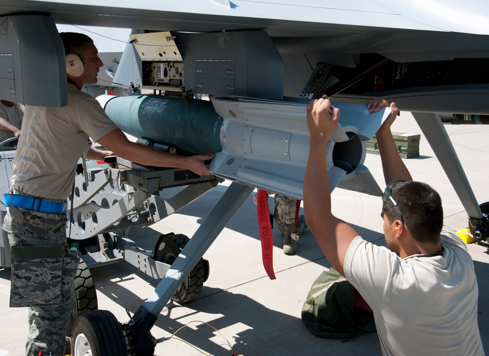 HOLLOMAN AIR FORCE BASE, N.M. -- A Staff Sergeant and Senior Airman from the 49th Maintenance Group load a GBU-12 Laser-Guided Bomb onto an aircraft July 8, 2011, during a quarterly load crew competition. For competitions, points are awarded during the actual weapons loading, a tool kit inspection and a uniform inspection. This particular load crew competition was Holloman’s first to feature a German Air Force load crew. (U.S. Air Force photo by Airman 1st Class Siuta B. Ika/Released)