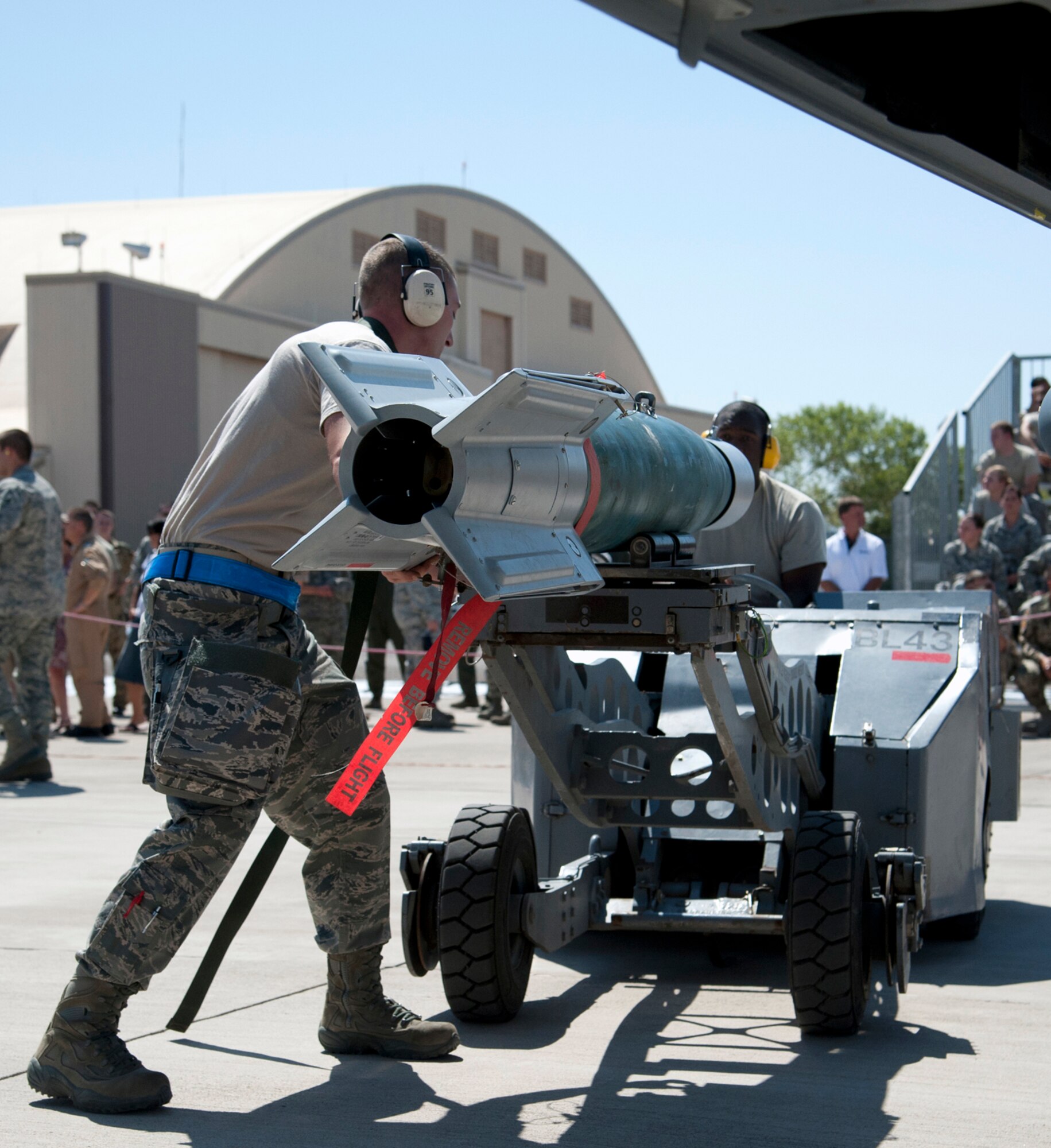 HOLLOMAN AIR FORCE BASE, N.M. -- A Staff Sergeant from the 49th Maintenance Group helps guide a GBU-12 Laser Guided Bomb being carried by an MJ-1 Jammer, driven by another Staff Sergeant from the 49th Maintenance Group, July 8, 2011, during a quarterly load crew competition. During a competition, each member has a set of tasks to carry out and work in teams of three or four, depending on the aircraft. This particular load crew competition was Holloman’s first to feature a German Air Force load crew. (U.S. Air Force photo by Airman 1st Class Siuta B. Ika/Released)