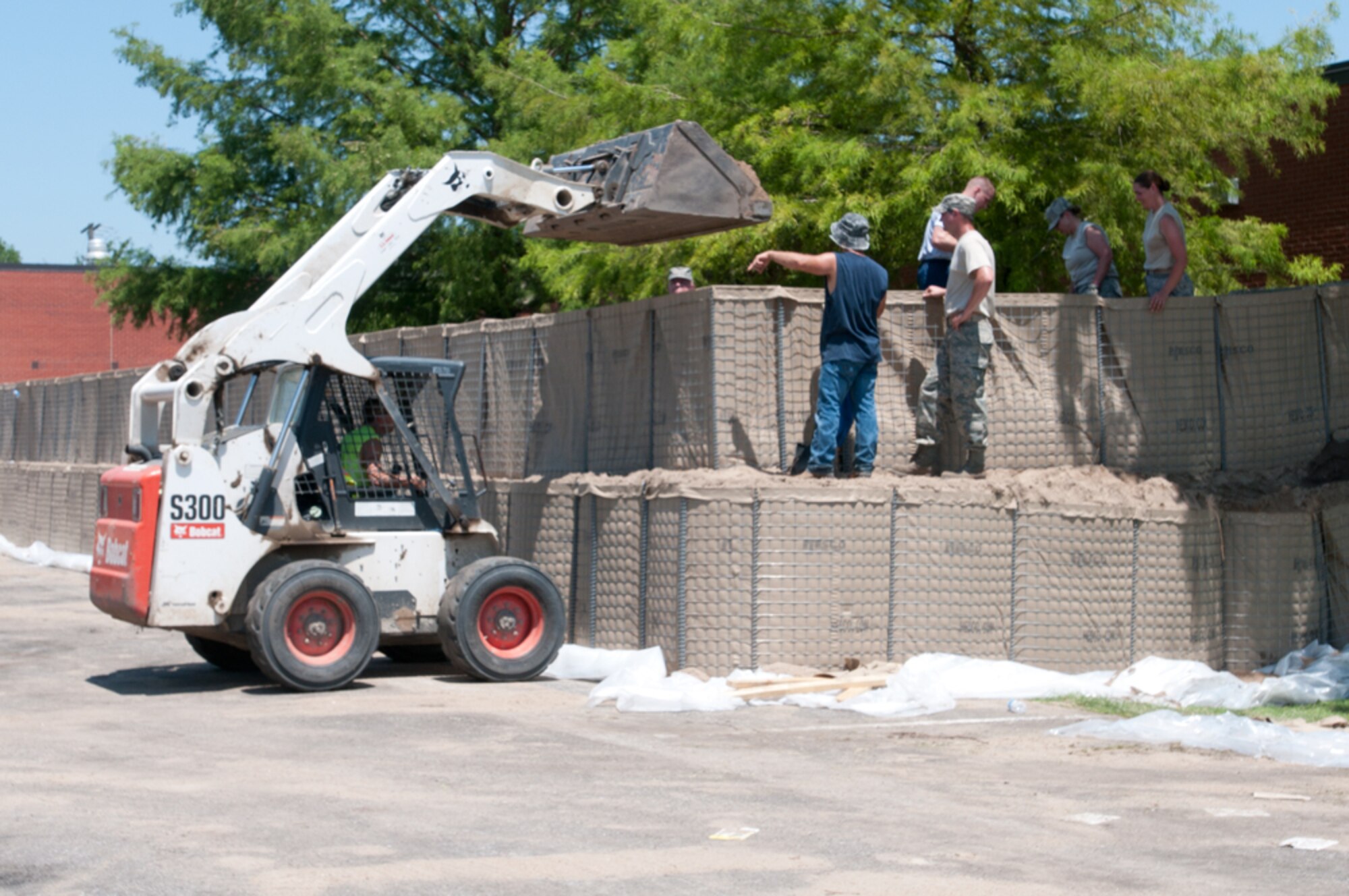 Airmen with the Missouri Air National Guard’s 139th Airlift Wing erect HESCO barriers around various buildings at Rosecrans Air National Guard Base, St. Joseph, Mo., July 12, 2011. The sand-filled barriers are being installed as a precautionary measure should the Missouri River breach the levees here. (U.S. Air Force photo by Staff Sgt. Michael Crane)