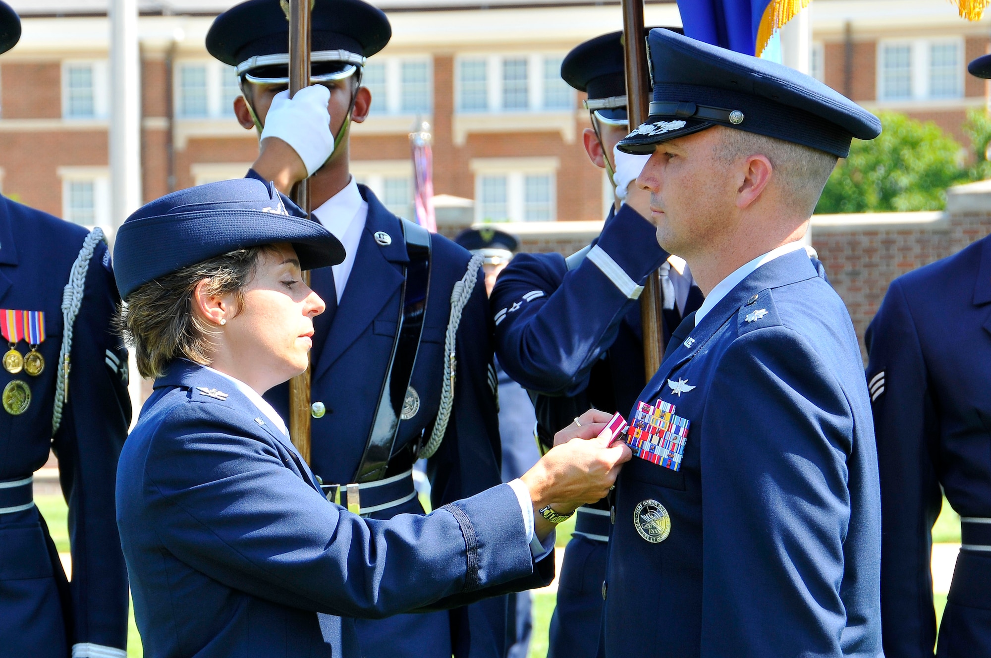 Col. Gina M. Humble, 11th Operations Group commander, presents the Meritorious Service Medal to Lt. Col. Raymond Powell, during a change of command ceremony July 12, at Joint Base Anacostia-Bolling, D.C. Humble lauded  Powell for his numerous accomplishments and achievements during his tenure as commander of the USAF Honor Guard.. (U.S. Air Force photo by Senior Airman Steele C. G. Britton)