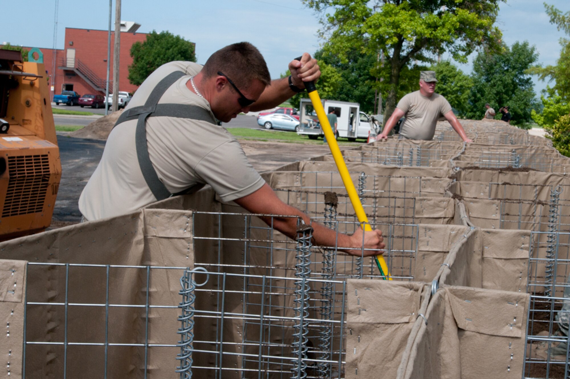 Airmen with the Missouri Air National Guard’s 139th Airlift Wing erect HESCO barriers around various buildings at Rosecrans Air National Guard Base, St. Joseph, Mo., July 12, 2011. The sand-filled barriers are being installed as a precautionary measure should the Missouri River breach the levees here. (U.S. Air Force photo by Staff Sgt. Michael Crane/Released)