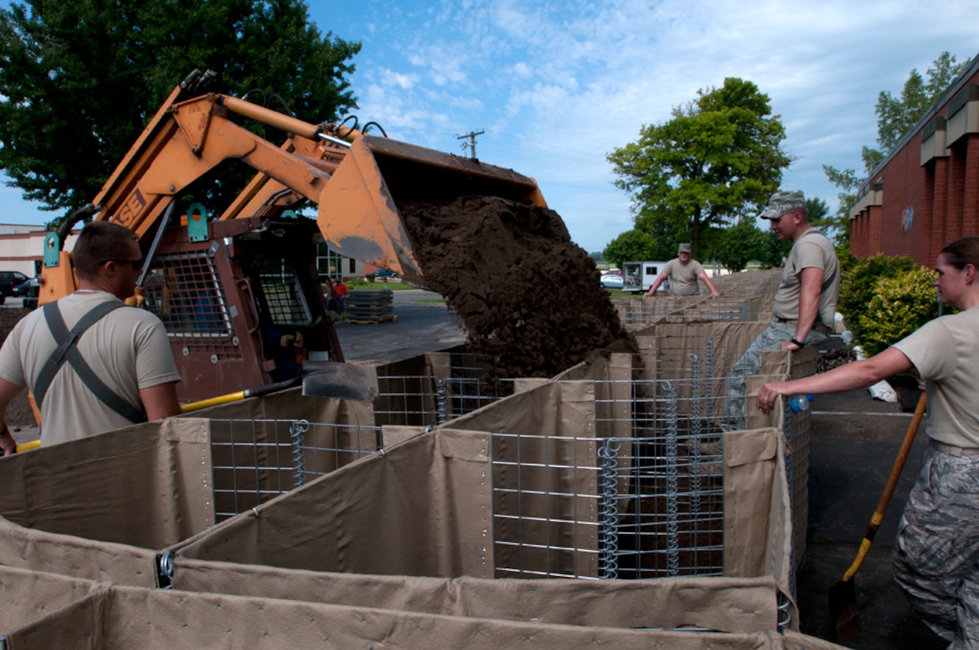 Airmen with the Missouri Air National Guard’s 139th Airlift Wing erect HESCO barriers around various buildings at Rosecrans Air National Guard Base, St. Joseph, Mo., July 12, 2011. The sand-filled barriers are being installed as a precautionary measure should the Missouri River breach the levees here. (U.S. Air Force photo by Staff Sgt. Michael Crane)