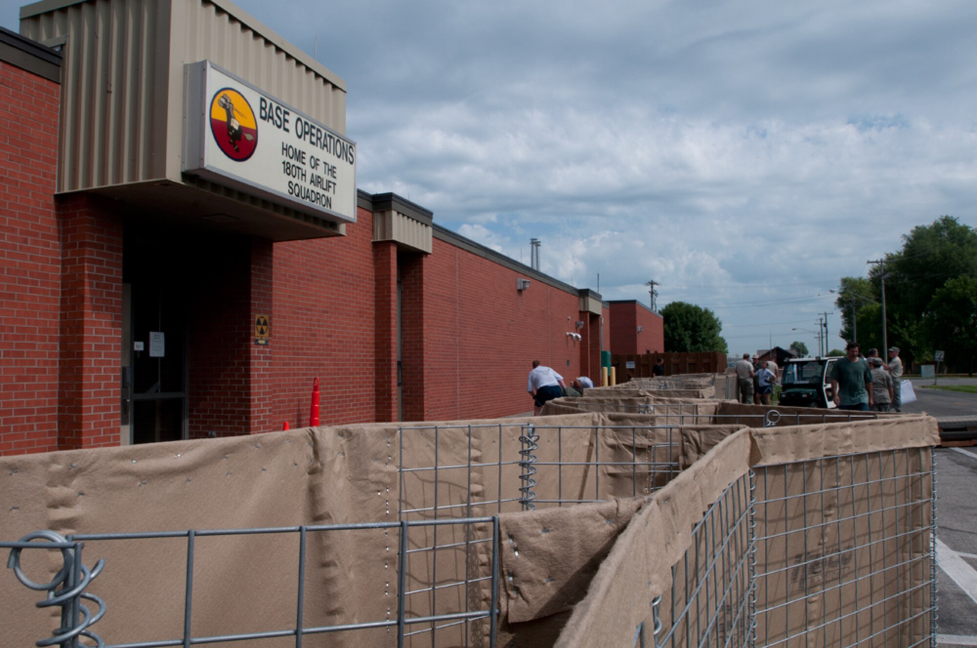 Airmen with the Missouri Air National Guard’s 139th Airlift Wing erect HESCO barriers around various buildings at Rosecrans Air National Guard Base, St. Joseph, Mo., July 12, 2011. The sand-filled barriers are being installed as a precautionary measure should the Missouri River breach the levees here. (U.S. Air Force photo by Staff Sgt. Michael Crane)