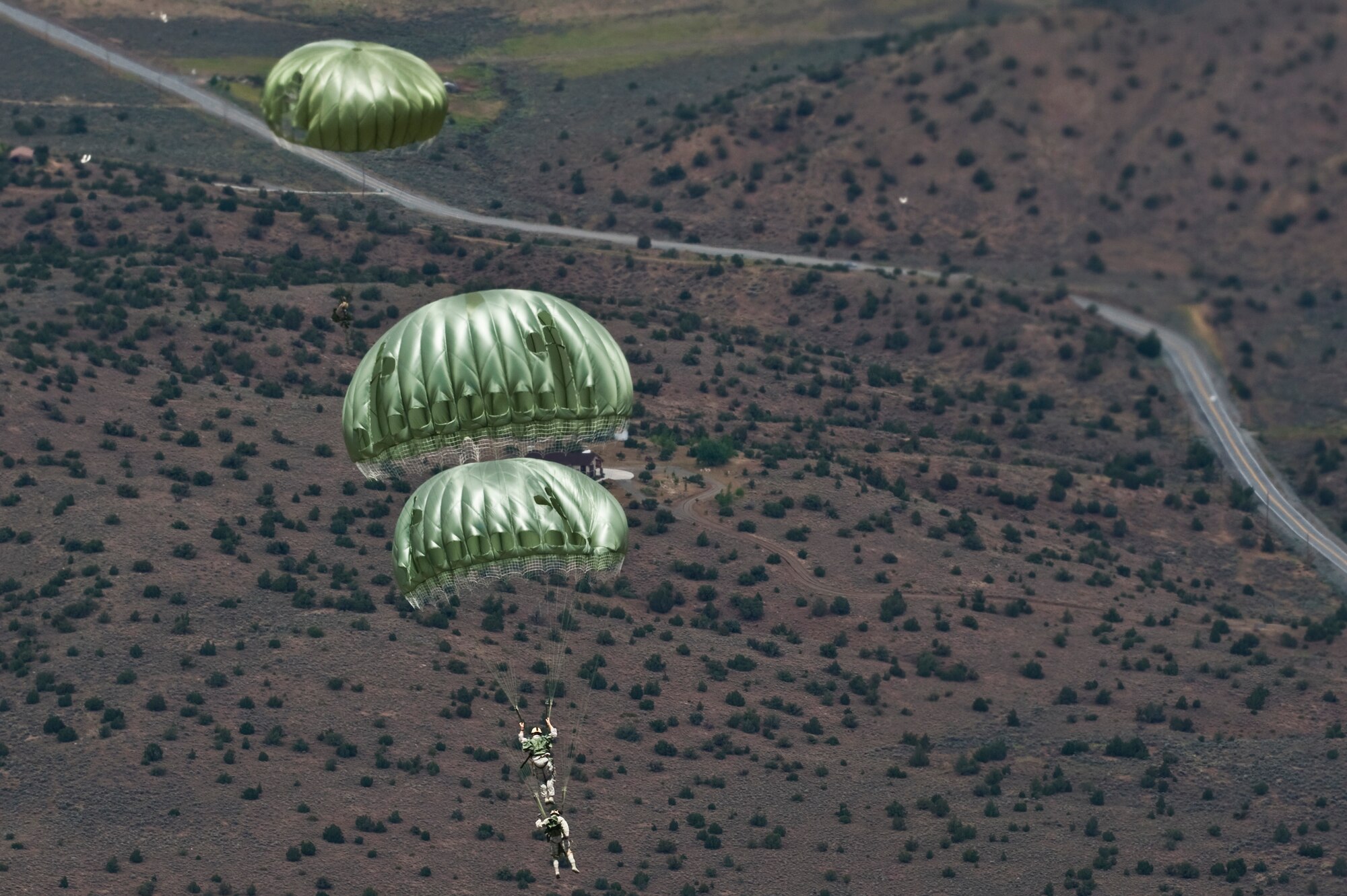 U.S. Air Force jumpers from the 820th RED HORSE Squadron airborne flight drop into a landing zone June 28, 2011, inside the Senator Harry Reid Readiness and Training Center in Stead, Nev.  Members of the Nevada Army National Guard 1st Battalion, 189th Aviation Company and the 820 RHS airborne flight trained together to improve their expertise in conducting air drops and sling-load operations. (U.S. Air Force photo by Senior Airman Brett Clashman/Released)

