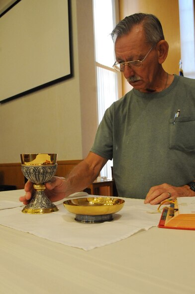 James O'Donnell, a volunteer, sets up a communion display in Chapel 2 on Barksdale Air Force Base, La., July 12. Chapel 2 offers daily mass Monday through Thursday starting at 11:35 a.m. The chapel provides Catholic and Protestant services, youth groups and singles programs. (U.S. Air Force photo/Airman 1st Class Micaiah Anthony)(RELEASED)