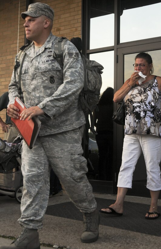 Senior Airman Justin Rogers, a member of the 108th Security Forces Squadron, a New Jersey Air National Guard unit, leaves his family behind as he prepares to board a bus at Joint Base McGuire-Dix-Lakehurst on July 12, 2011. Rogers, along with approximately 30 other security forces members, have deployed to Southwest Asia in support of Operation New Dawn where they will be responsible for maintaining security at the air base. (U.S. Air Force photo/Airman Kellyann Novak) 