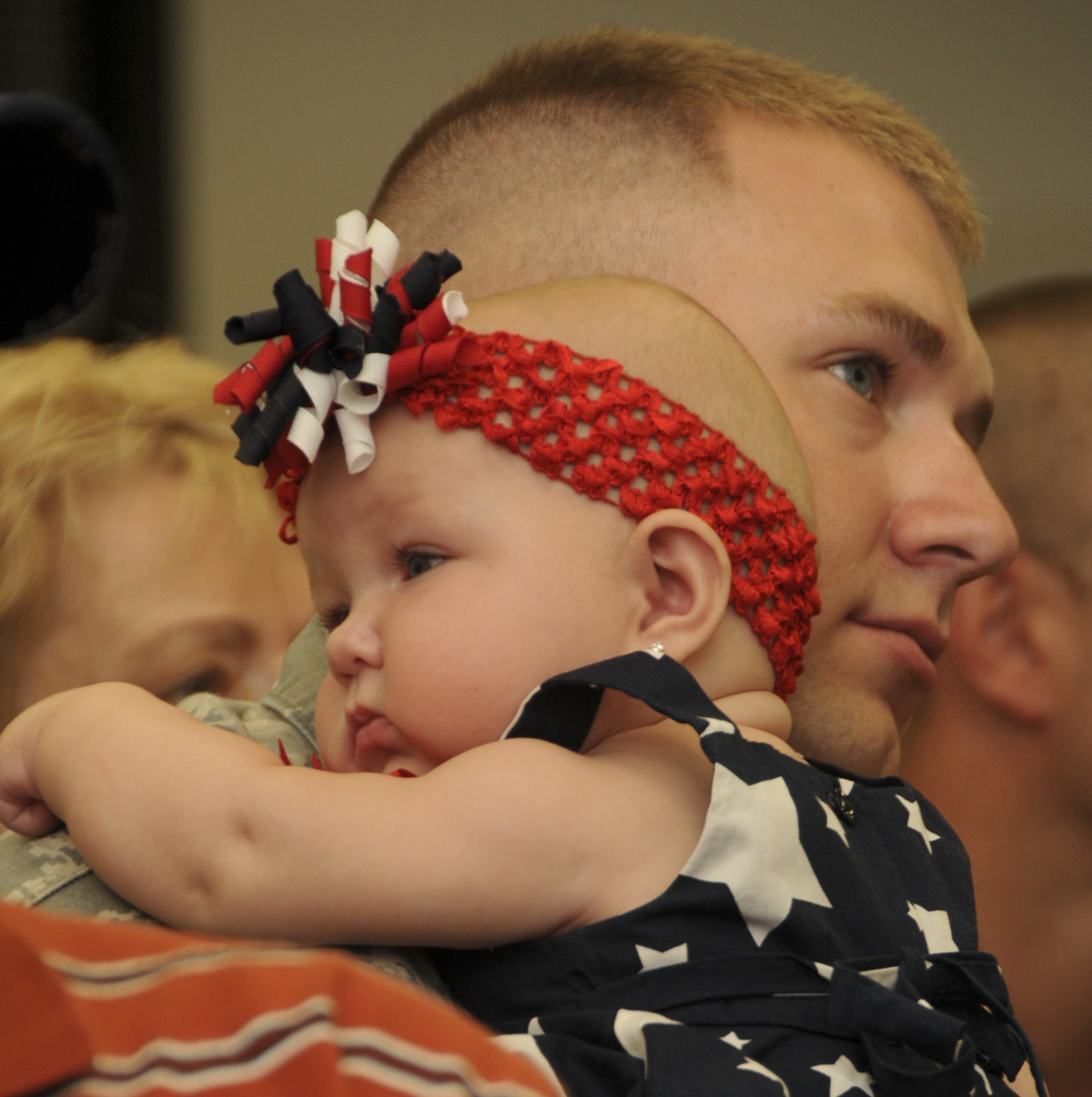 Senior Airman Jeffrey Stich, a member of the 108th Security Forces Squadron, a New Jersey Air National Guard unit, holds his daughter, Kyleigh, during a farewell ceremony at Joint Base McGuire-Dix-Lakehurst on July 12, 2011. Stich, along with about 30 other security forces members, have deployed to Southwest Asia in support of Operation New Dawn where they will be responsible for maintaining security at the air base. (U.S. Air Force photo/Airman Kellyann Novak)