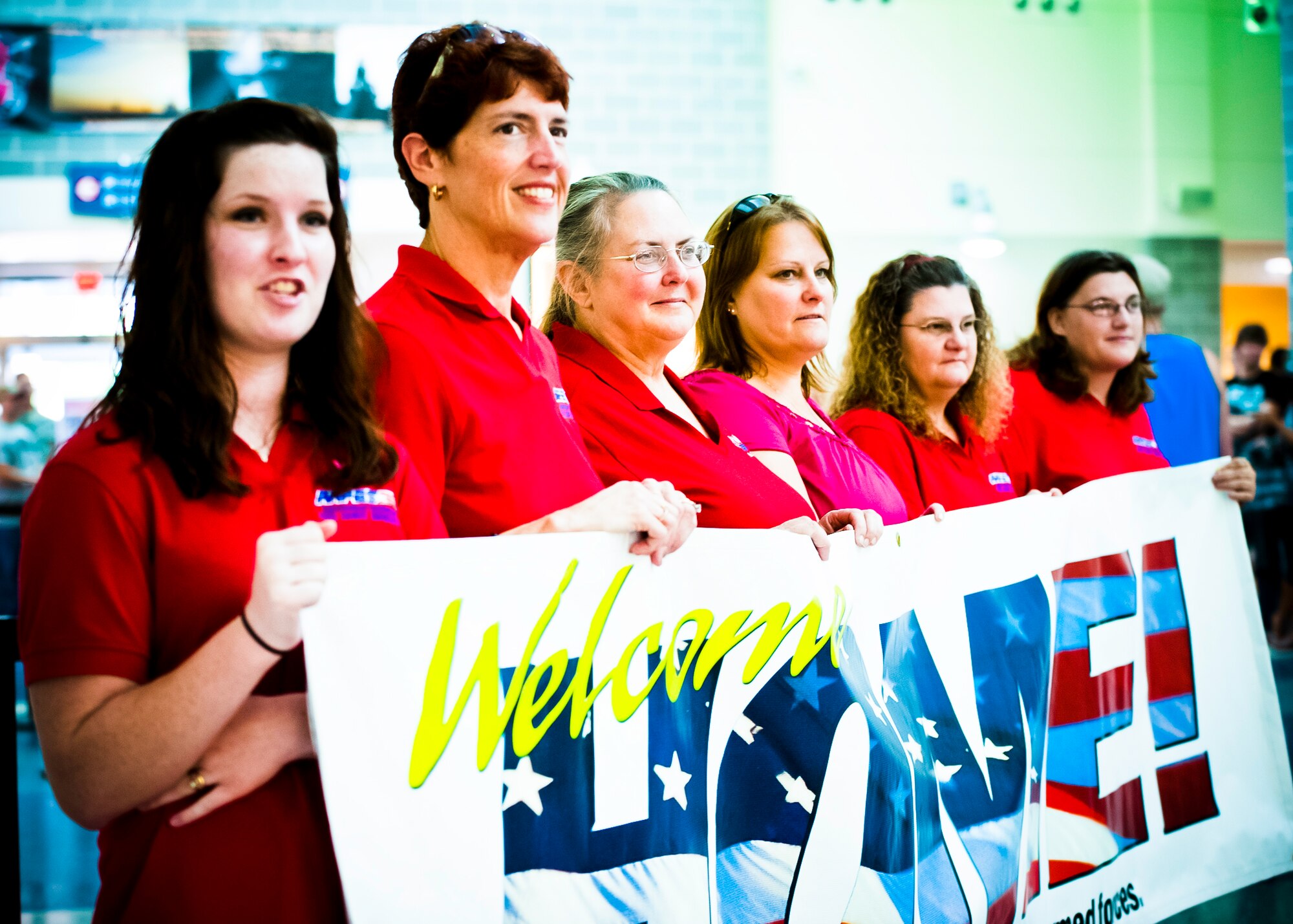 The Red Shirt Brigade waits for troops returning from deployments at the Northwest Florida Regional Airport July 8.  Christi Cook, (second from left) leads the brigade attending every send-off and homecoming of area service members.  She said she estimates the brigade has said goodbye and welcomed back more than 3,000 troops.  (U.S. Air Force photo/Samuel King Jr.)