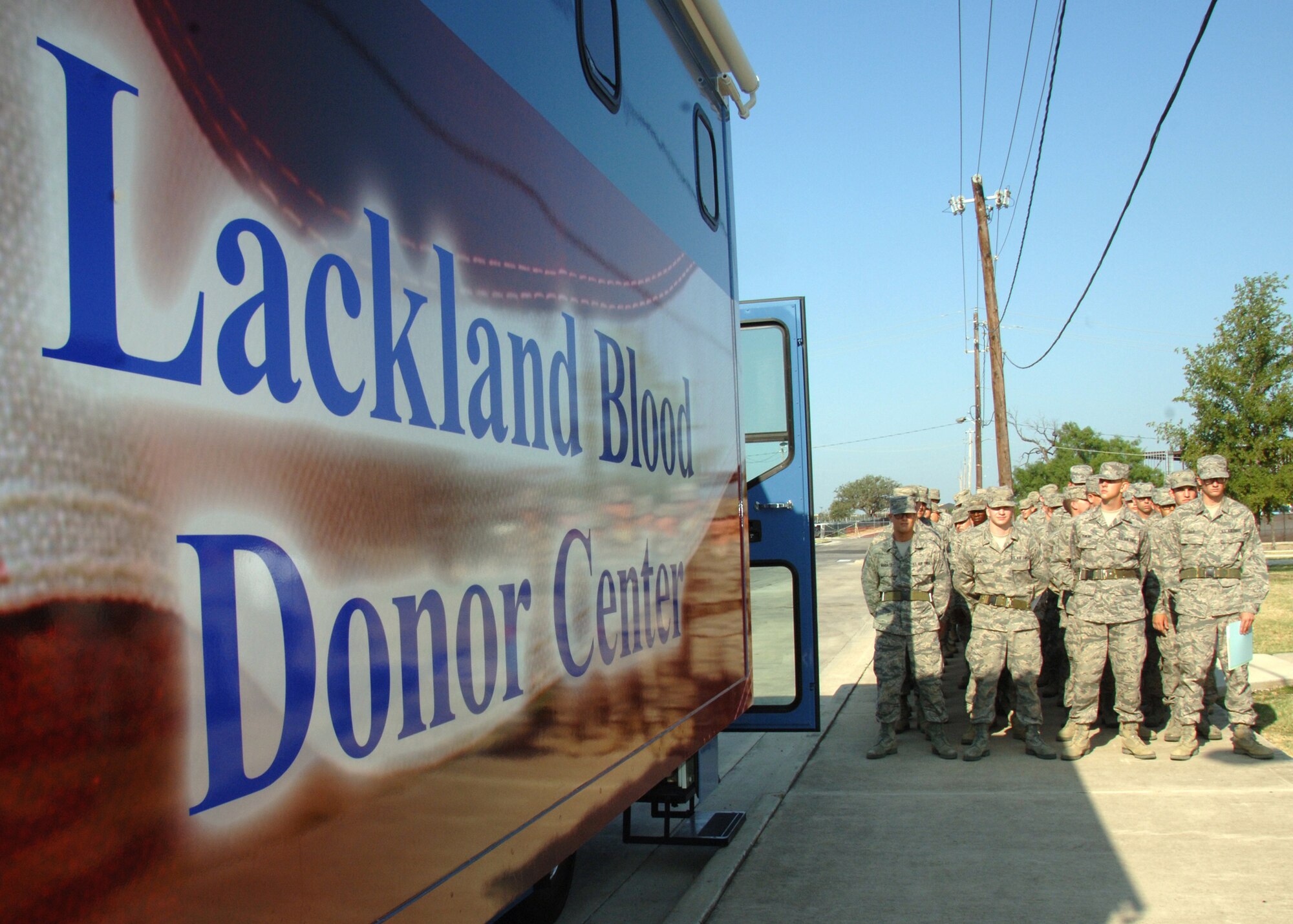 Basic military trainees from the 323rd Training Squadron stand at ease in front of the bloodmobile July 6, 2011, at the Blood Donor Center, Lackland Air Force Base, Texas. The center collects about 1,100 units of blood each month and depends on the Lackland BMTs and other donors. More than 60 trainees attended a ribbon-cutting event, unveiling the new vehicle that will be used to conduct blood drives at locations in San Antonio, Texas. (U.S. Air Force photo/Senior Airman Kevin Iinuma)