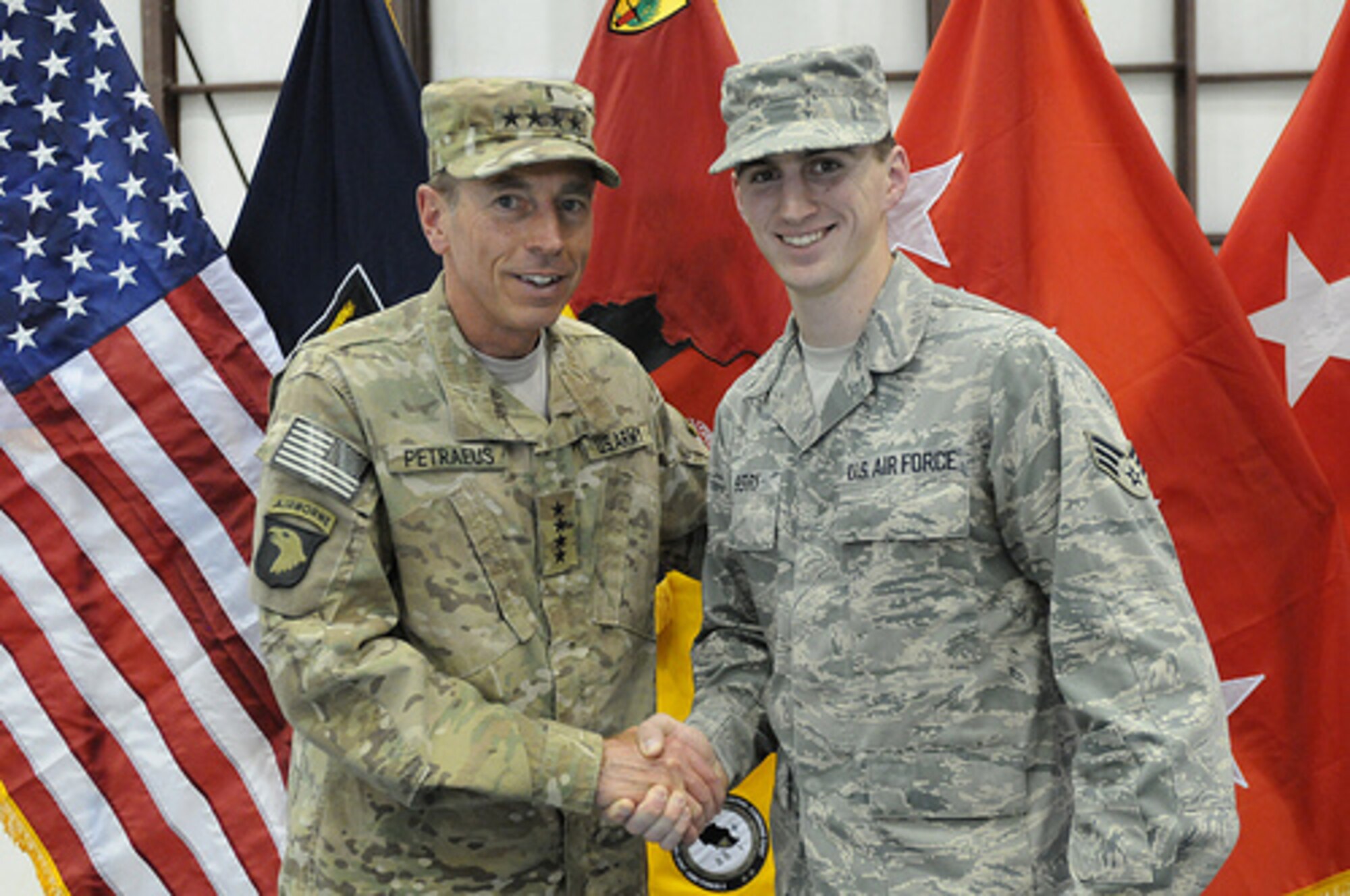 BAGRAM AIRFIELD, Afghanistan – Senior Airman Matthew Perry, 389th Expeditionary Fighter Squadron, is congratulated by Gen. David Petraeus, Director of Central Intelligence Agency, after reenlisting here July 4. In celebration of the 235th 4th of July, 235 enlisted men and women were handpicked to attend a ceremony in which they either reenlisted or reaffirmed their enlistment with Petraeus giving the oath. (Courtesy photo)
