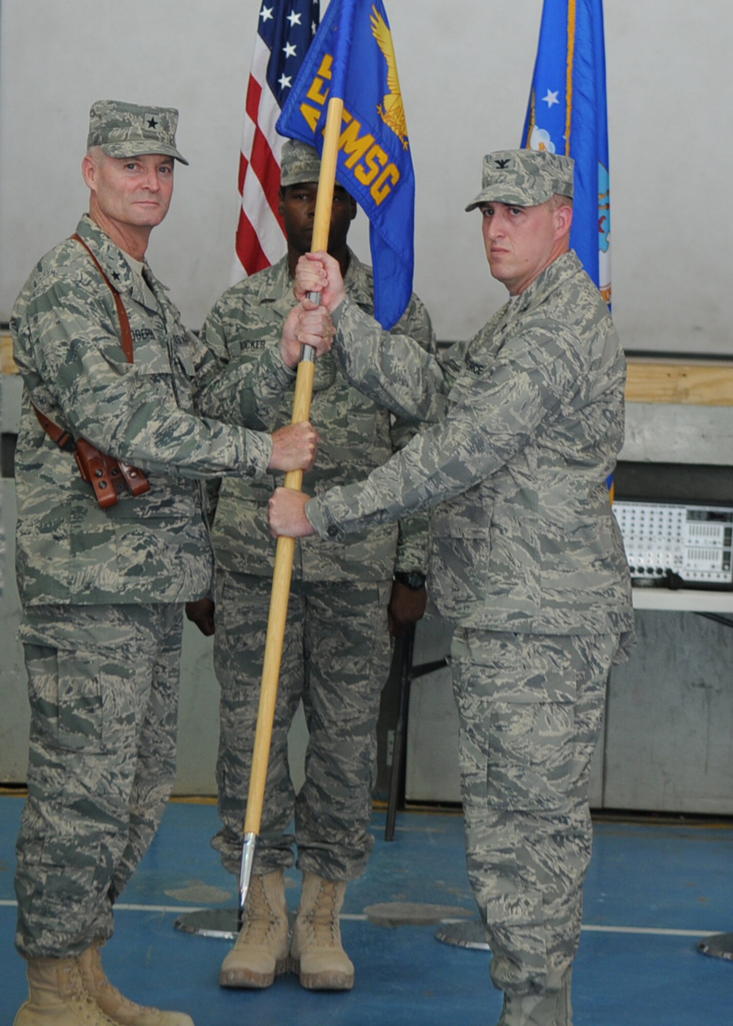 BAGRAM AIRFIELD, Afghanistan -- Brig. Gen. Darryl Roberson, 455th Air Expeditionary Wing commander, passes the 455th Expeditionary Mission Support Group guidon to Colonel Erik Rinquist, incoming 455th EMSG commander, during a formal change of command ceremony here July 11, 2011. 