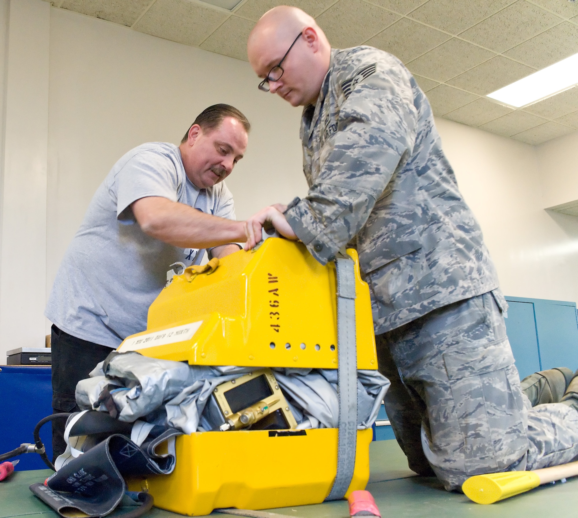 Kerry Lloyd (left), 436th Operations Support Squadron Aircrew Flight Equipment slide and raft packing specialist, and Staff Sgt. Jerry Baker, 436 OSS AFE craftsman, pack a more than 40-foot long C-5 Galaxy emergency slide into a small box July 7, 2011 at Dover Air Force Base, Del. Dover AFB has more than 70 slides, which are rotated for inspection. (U.S. Air Force photo by Roland Balik)
