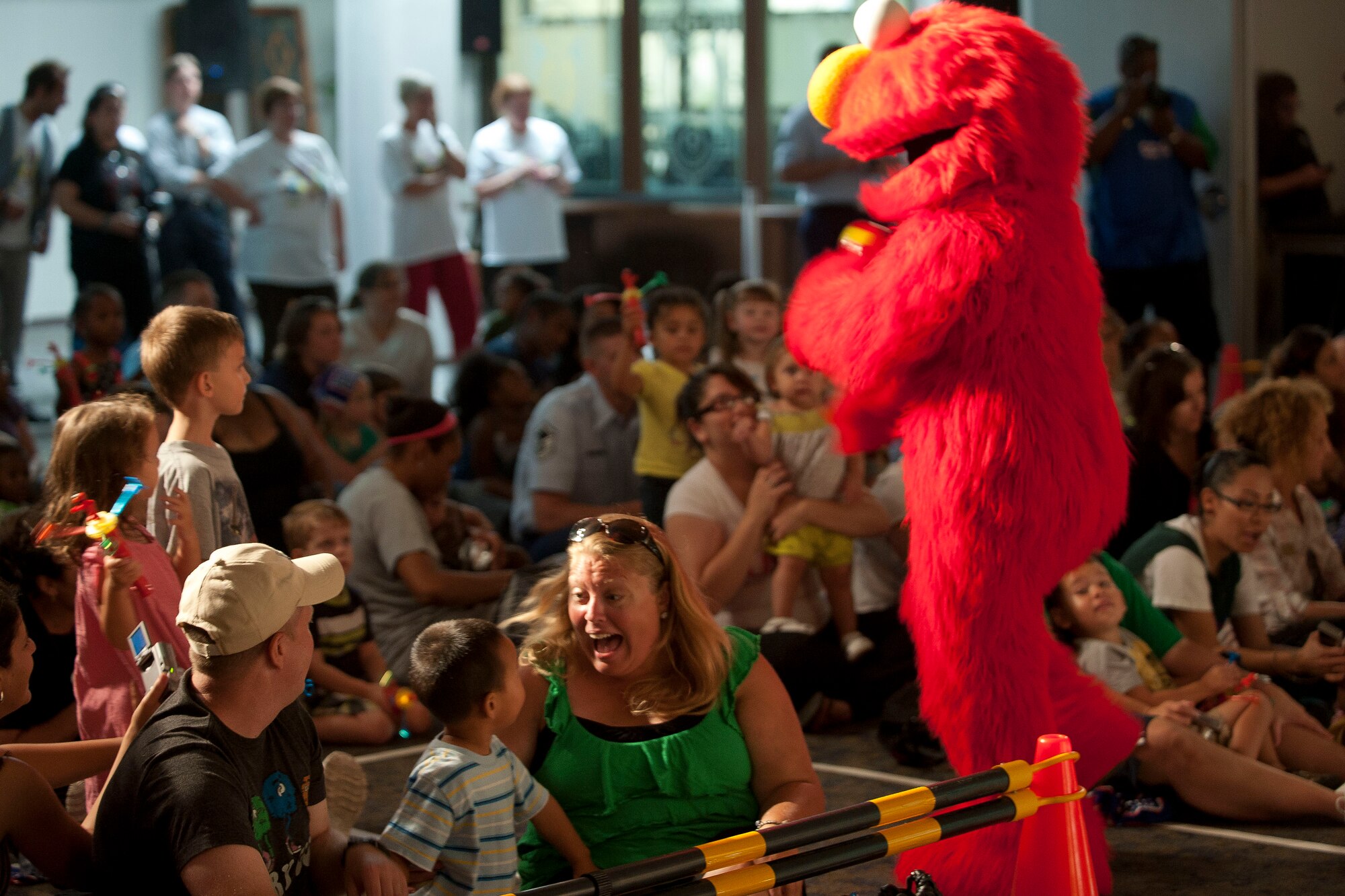 Sesame Street’s Elmo walks into the crowd during the Sesame Street/USO Experience July 11, 2011, at the Club Complex Ballroom at Incirlik Air Base, Turkey. The performance was part of a tour to U.S. military bases worldwide geared specifically toward helping children of military members deal with the stresses of deployment. (U.S. Air Force photo by Airman 1st Class Clayton Lenhardt/Released)