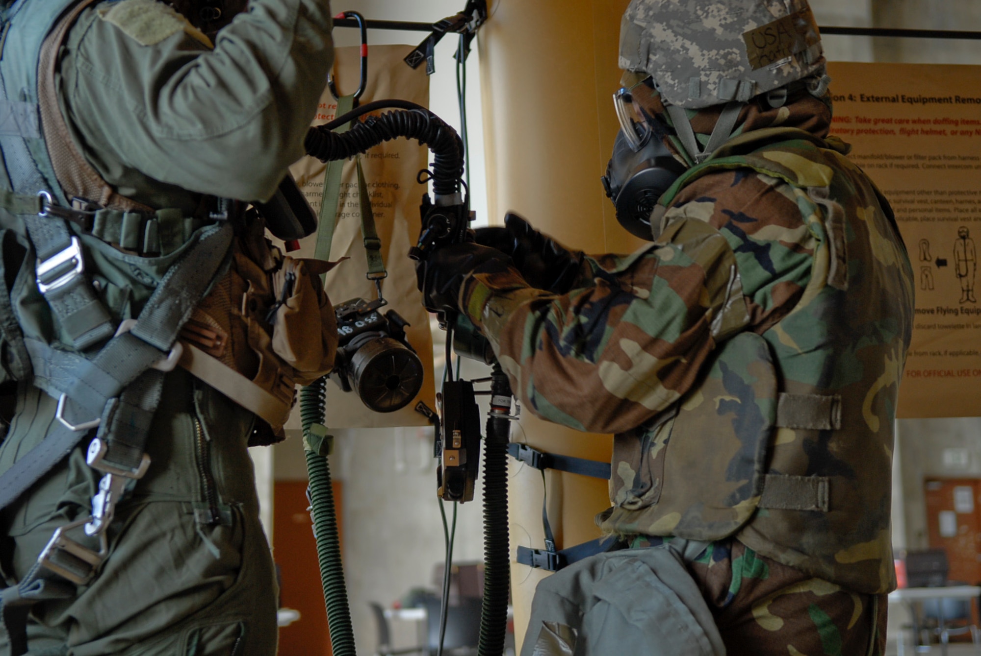 A Kadena ground crew member removes the external equipment from an aircrew member proceeding through a simulated decontamination line July 12 during Beverly High 11-5, a Local Operational Readiness Exercise at Kadena Air Base, Japan. LOREs give Kadena Airmen the chance to receive hands-on training, preparing them for possible real-world contingencies. (U.S. Air Force photo/ Airman 1st Class Tara A. Williamson) 
