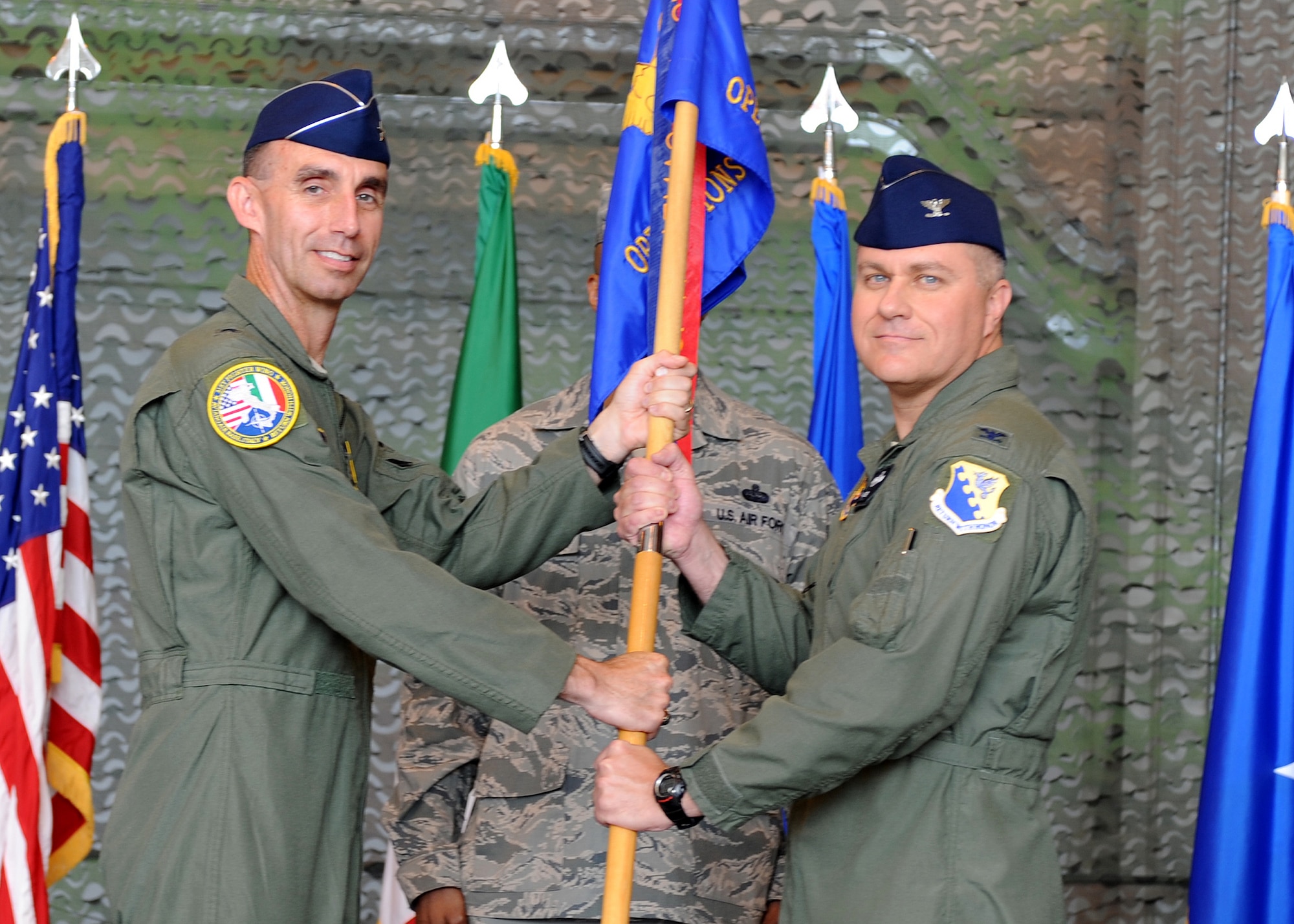 Brig. Gen. Scott J. Zobrist, 31st Fighter Wing commander, passes the 31st Operations Group guidon to Col. David W. Walker during the 31st OG change of command ceremony July 7 at Aviano Air Base, Italy. Walker took command of the 31st OG from Col. Patrick J. S. Miller. Prior to assuming his current duties, Walker was a student at the Air War College at Maxwell Air Force Base, Ala. (U.S. Air Force photo/Staff Sgt. Nadine Y. Barclay)