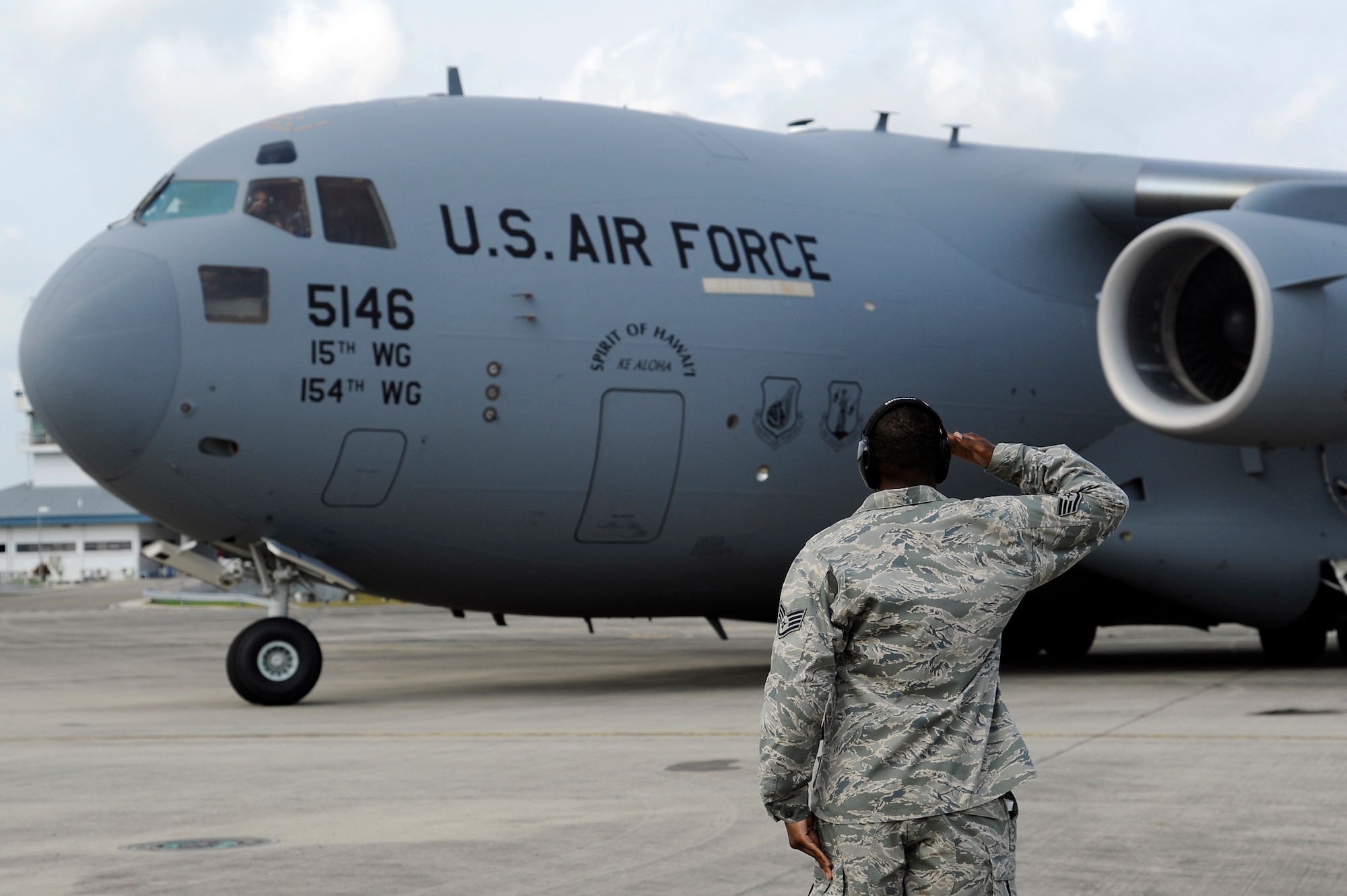Brunei Darussalam -- Staff Sgt. Thomas Fleming, 15th Aircraft Maintenance Squadron flying crew chief, salutes as a C-17 Globemaster III taxis for take-off during the 3rd Biennial Brunei Darussalam International Defense Exhibition July 8. This was the first time that Misawa Air Base participated in this event. (U.S. Air Force photo/Staff Sgt. Marie Brown/Released)