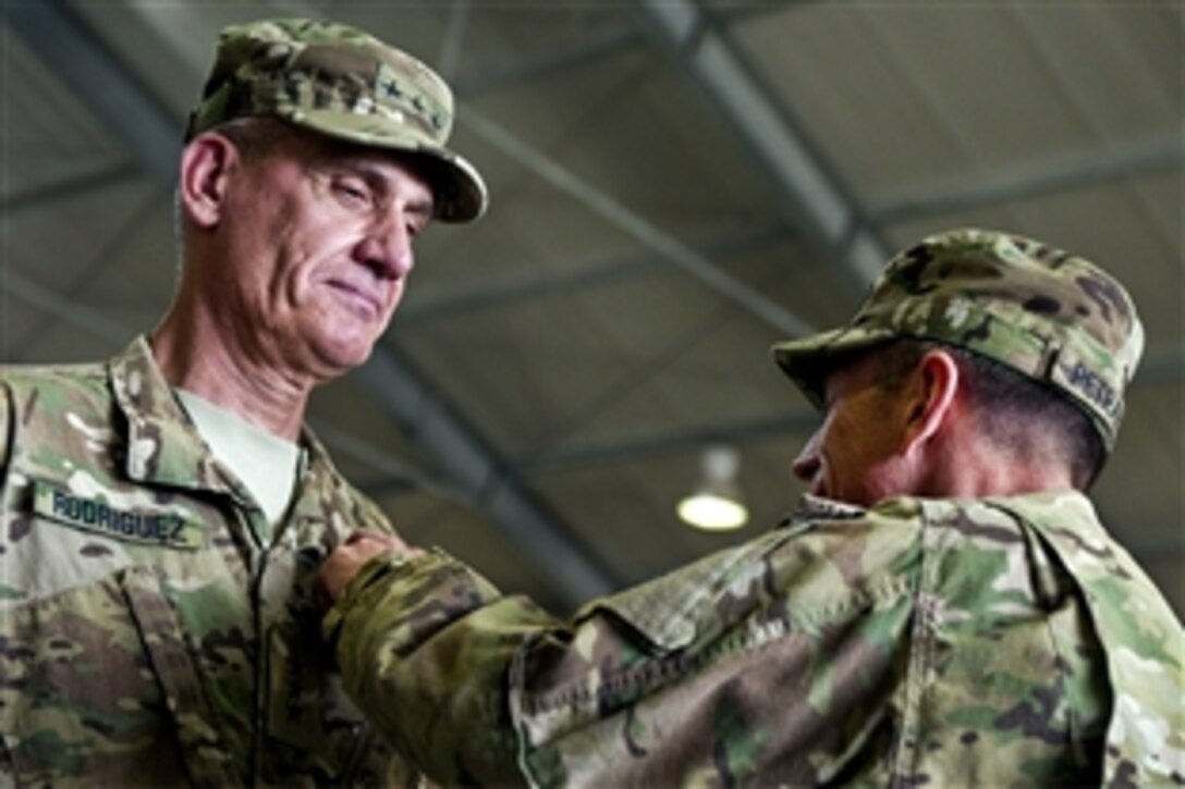 U.S. Army Lt. Gen. David Rodriguez, the outgoing commander of NATO's International Security Assistance Force Joint Command, receives the NATO Meritorious Service Medal from U.S. Army  Gen. David H. Petraeus in Kabul, Afghanistan, July 11, 2011. Petraeus is the commander of U.S. and international forces in Afghanistan.