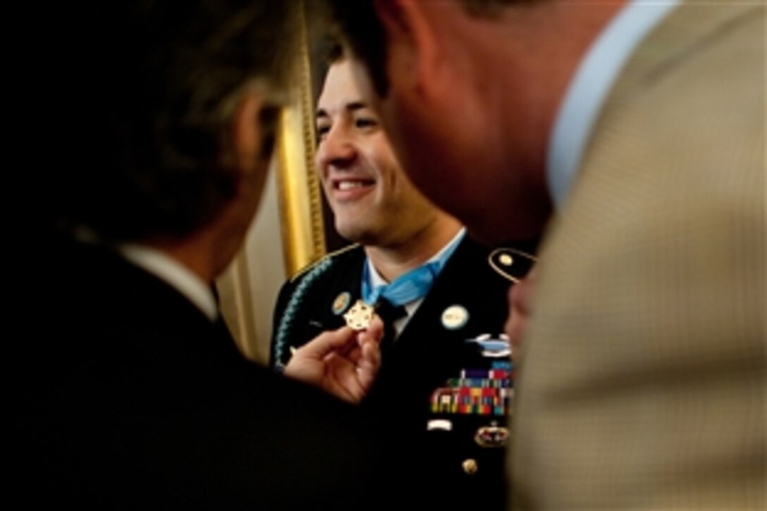 Friends of Army Sgt. 1st Class Leroy Arthur Petry inspect the Medal of Honor he received at the White House in Washington, D.C., July 12, 2011. 