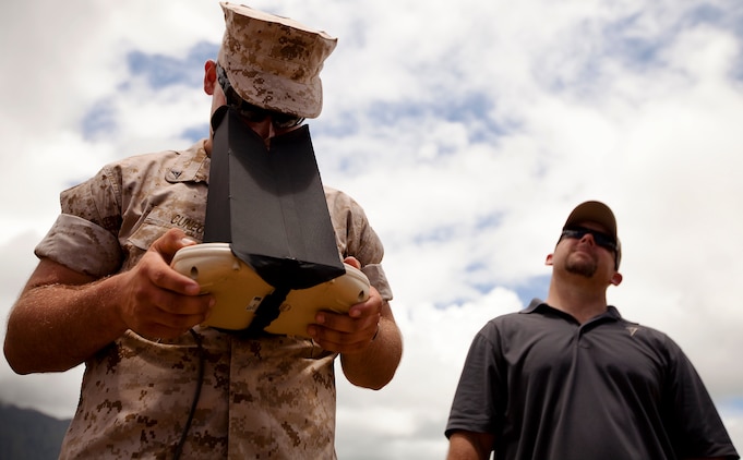 Lee Blackwell, an unmanned aircraft system flight instructor with Rally Point Management, watches as Lance Cpl. Michael Cuneo, a rifleman with India Company, 3rd Battalion, 3rd Marine Regiment, uses a viewfinder to track the location of his RQ-11B Raven unmanned aircraft system during UAS flight operations at Marine Corps Training Area Bellows, Hawaii, July 12, 2011. During 3/3’s upcoming fall deployment to Afghanistan, Cuneo, from Newcastle, Calif., will fulfill duties as a company-level intelligence cell Marine for India Co. “Gathering intelligence makes an impact on a daily basis,” Cuneo said. “If I can gather intelligence for my squad and send it up to higher, I can make an impact at a larger level than just in my squad’s area of operation.”