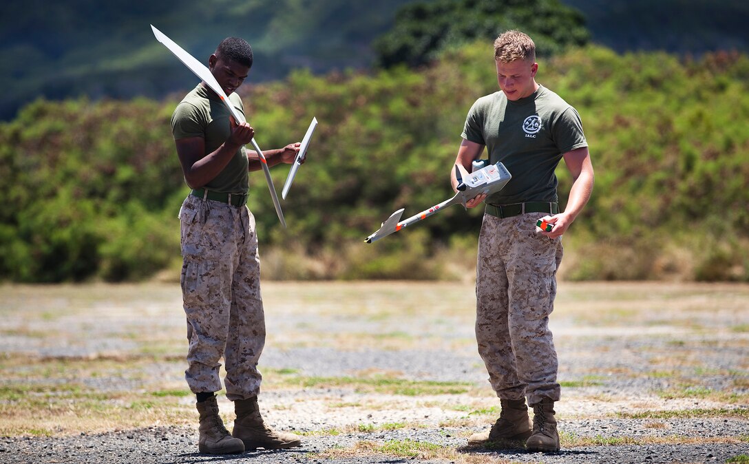 Lance Cpls. Daniel Shannon and Andrew Donnelley, an intelligence clerk and a team leader with 3rd Battalion, 3rd Marine Regiment, pick up the pieces of an RQ-11B Raven unmanned aircraft system following UAS flight operations at Marine Corps Training Area Bellows, Hawaii, July 12, 2011. Flying between 300 and 1,000 feet over MCTAB, the Raven’s cameras collected real-time video of the training area, recording the information through the laptop before landing itself and breaking into pieces to be re-assembled. In only a few short months, the 3/3 Marines will use the Raven in Afghanistan to gather intelligence, allowing battalion leaders to analyze and use the information for reconnaissance, surveillance and target acquisition.