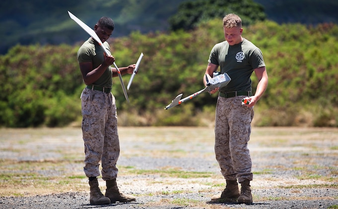 Lance Cpls. Daniel Shannon and Andrew Donnelley, an intelligence clerk and a team leader with 3rd Battalion, 3rd Marine Regiment, pick up the pieces of an RQ-11B Raven unmanned aircraft system following UAS flight operations at Marine Corps Training Area Bellows, Hawaii, July 12, 2011. Flying between 300 and 1,000 feet over MCTAB, the Raven’s cameras collected real-time video of the training area, recording the information through the laptop before landing itself and breaking into pieces to be re-assembled. In only a few short months, the 3/3 Marines will use the Raven in Afghanistan to gather intelligence, allowing battalion leaders to analyze and use the information for reconnaissance, surveillance and target acquisition.