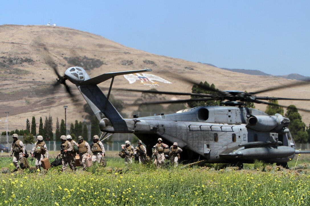 Marines with Marine Medium Helicopter Squadron 268 (Reinforced) exit a CH-53E Super Stallion at Camp San Luis Obispo, Calif., July 12. The Marines set up a forward arming and refueling point during the 11th Marine Expeditionary unit's large-scale exercise with ocean and urban-based scenarios. The squadron is the aviation combat element for the unit.