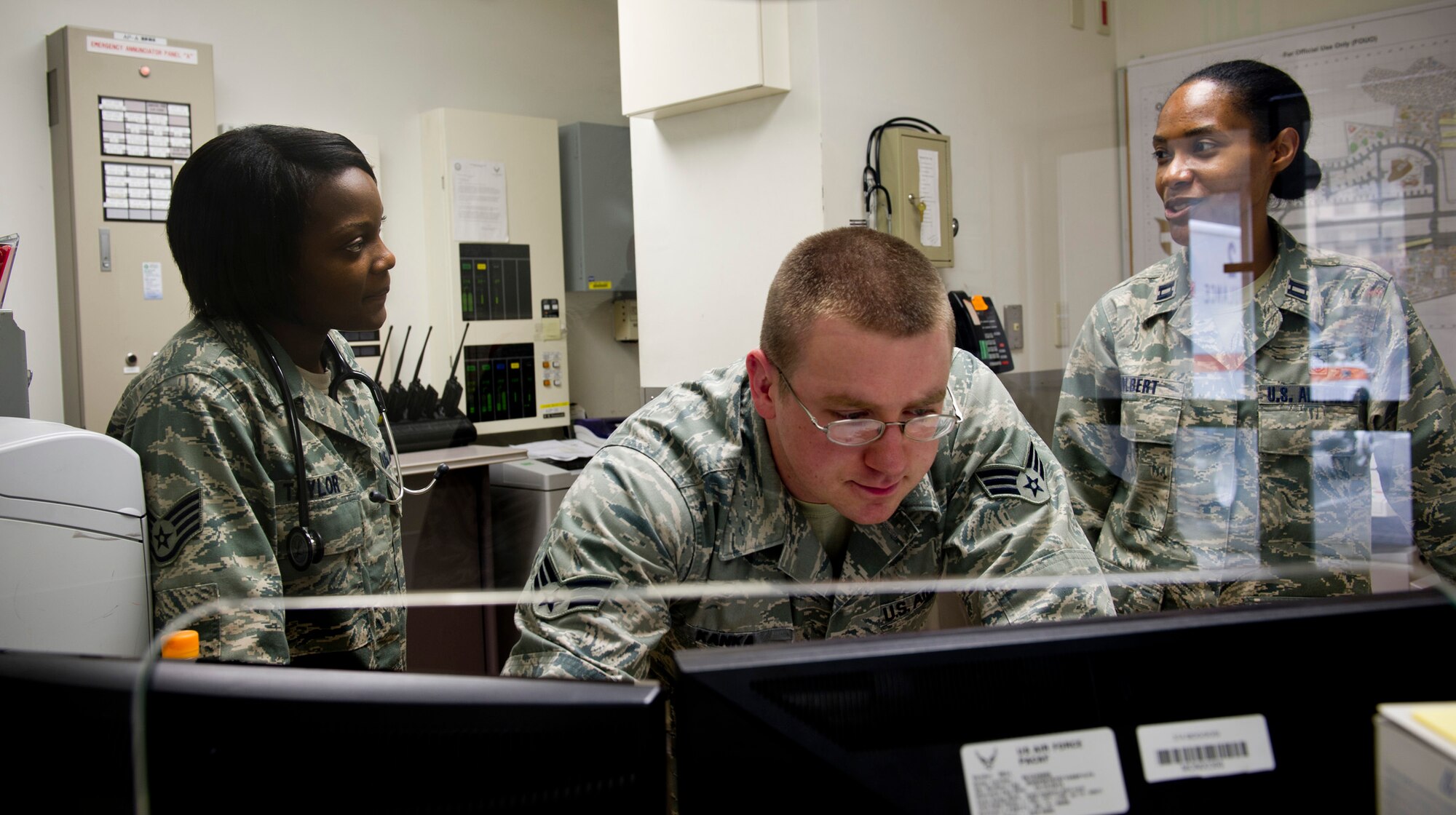 YOKOTA AIR BASE, Japan -- Staff Sgt. Raven Taylor (left), 374th Medical Operations Squadron medical technician, talks about incoming patients with Senior Airman Taylor Kanka, 374th MDOS medical technician, and Capt. Westina Tolbert, 374th Medical Operations Squadron nurse, in the Urgent Care Center at Yokota Air Base, Japan, July 8, 2011. Sergeant Taylor was named one of the Air Force's 12 Outstanding Airmen of the Year for 2011 for her work at her previous base, Eielson Air Force Base, Alaska. (U.S. Air Force photo/Staff Sgt. Samuel Morse)