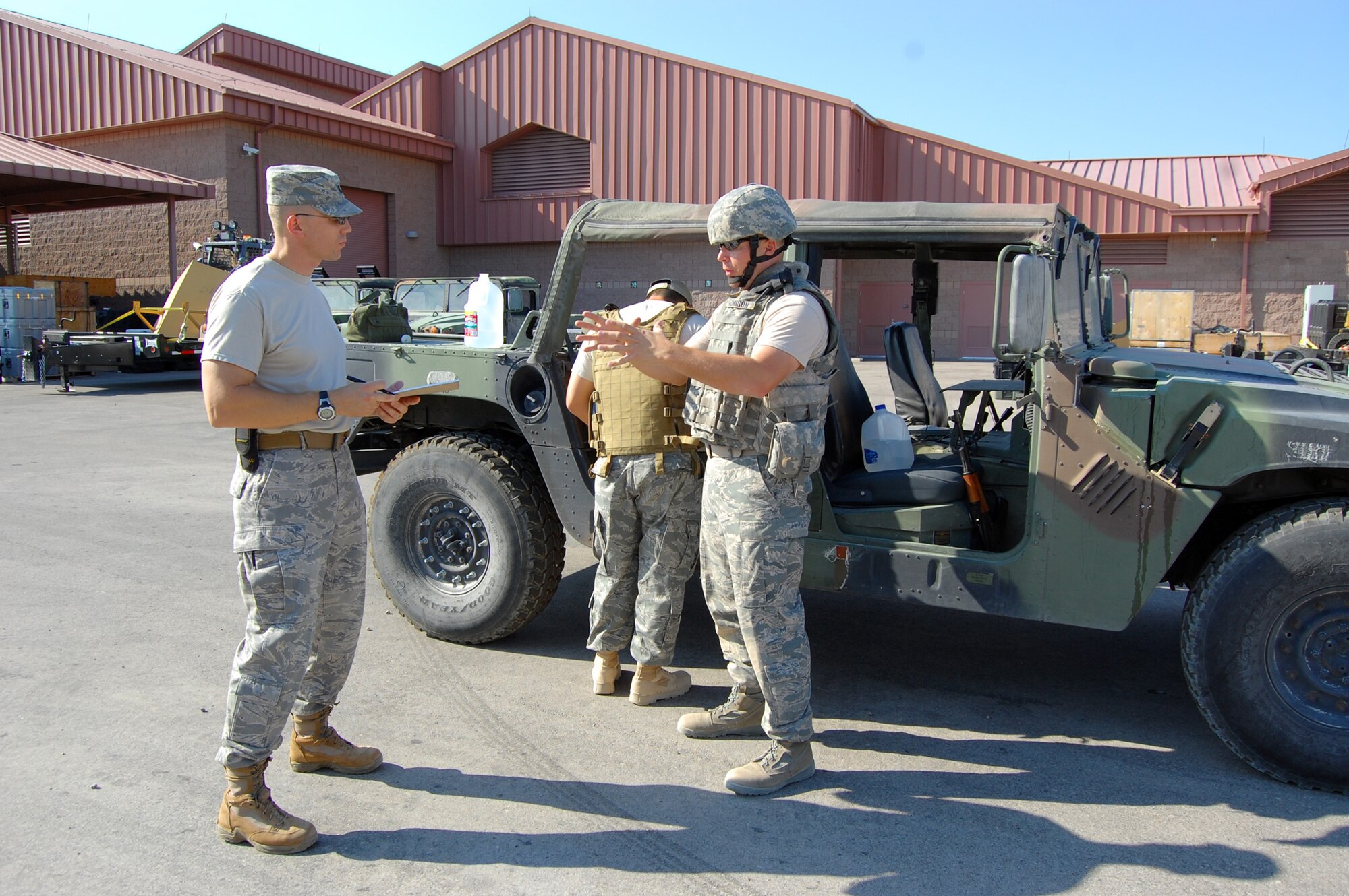 NELLIS AIR FORCE BASE, Nev. -- (far right) Tech. Sergeant Mac Johnson, 926th Civil Engineer Flight explosive ordnance disposal team leader, debriefs Capt. Daniel Tufts (far left), 926th CEF commander, on the process he used to identify a conventional weapon during an exercise here July 9. (U.S. Air Force photo/Capt. Jessica Martin)