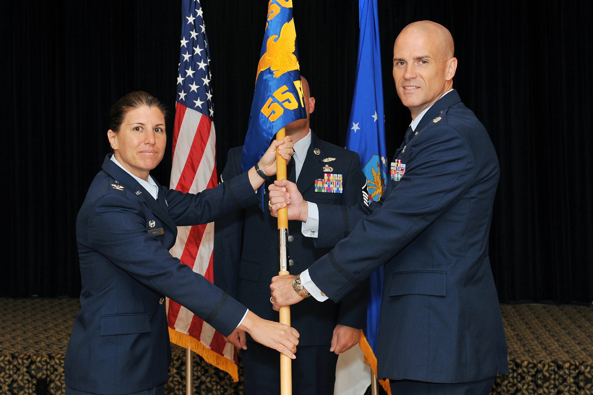 U.S. Air Force Col. Andrea Tullos, 55th Mission Support Group commander, passes the guidon to Lt. Col. Thomas Walsh II, incoming 55th Force Support Squadron commander, during a change of command ceremony inside the Patriot Club on Offutt Air Force Base, Neb., on July 13. (U.S. Air Force Photo by Charles Haymond/Released)
