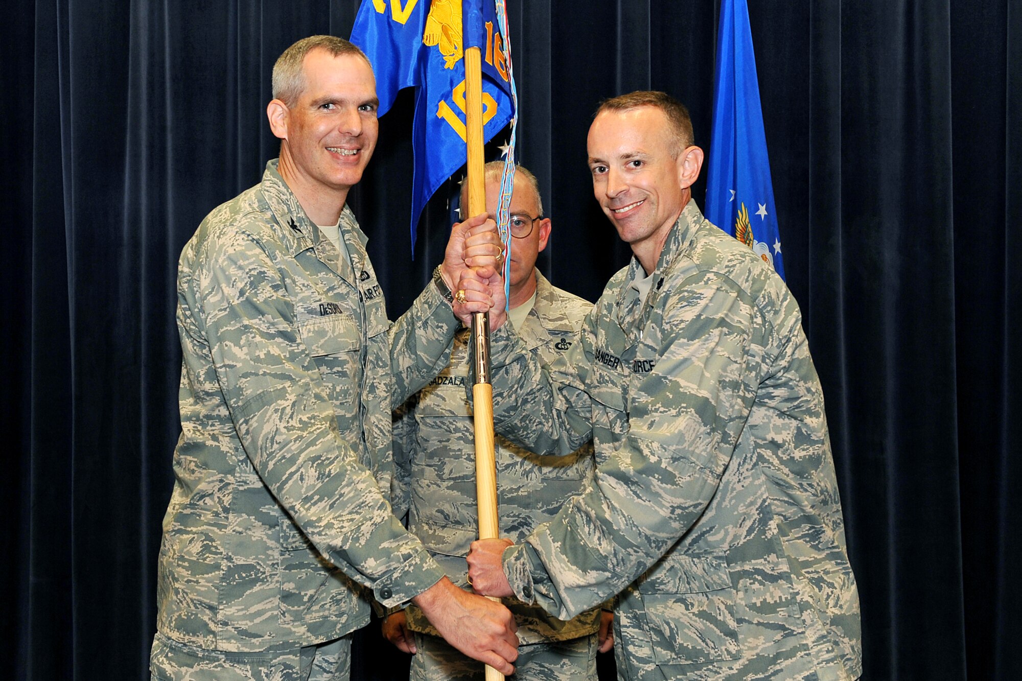 U.S. Air Force Lt. Col Neil Sanger, 16th Weather Squadron commander, relinquishes command and passes the guidon to Col. Steven DeSordi, 2nd Weather Group commander, during a change of command ceremony inside the Air Force Weather Agency auditorium on Offutt Air Force Base, Neb., on July 11. 

(U.S. Air Force Photo by Charles Haymond/Released)
