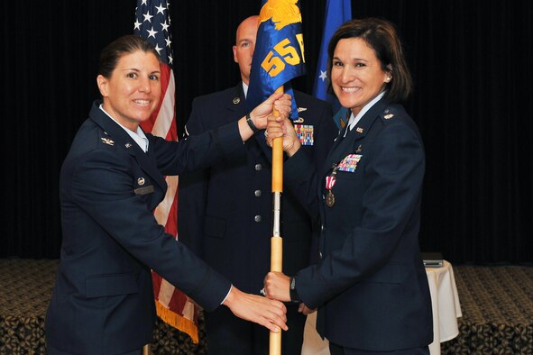 U.S. Air Force Lt. Col. Denise Cooper, 55th Force Support Squadron, relinquishes command and passes the guidon to Col. Andrea Tullos, 55th Mission Support Group commander, during a change of command ceremony inside the Patriot Club on Offutt Air Force Base, Neb., on July 13. (U.S. Air Force Photo by Charles Haymond/Released) 