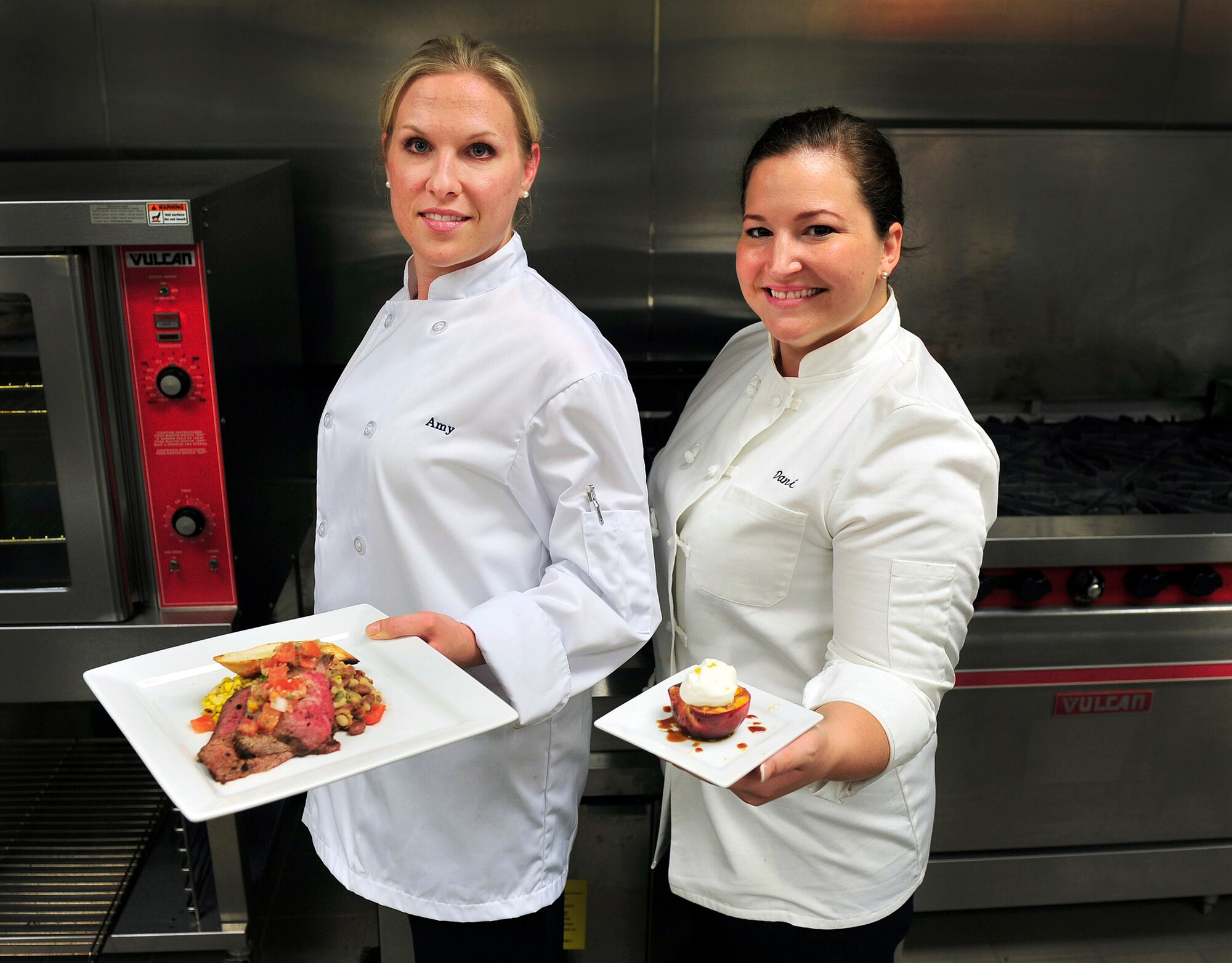 Staff Sgt. Amy Gillilan and Tech. Sgt. Danielle Sloan, flight attendants, show off the meal they thoughtfully prepared on Scott Air Force Base, Ill June 29, 2011. Sergeant Gillilan and Sloan will be representing Scott at the 2011 Rodeo in the culinary competition.  In preparation for the event they have been cooking meals with the secret ingredient “beef” for multiple audiences to get feedback and improve the meal.  (U.S. Air Force photo/Staff Sgt. Stephenie Wade)