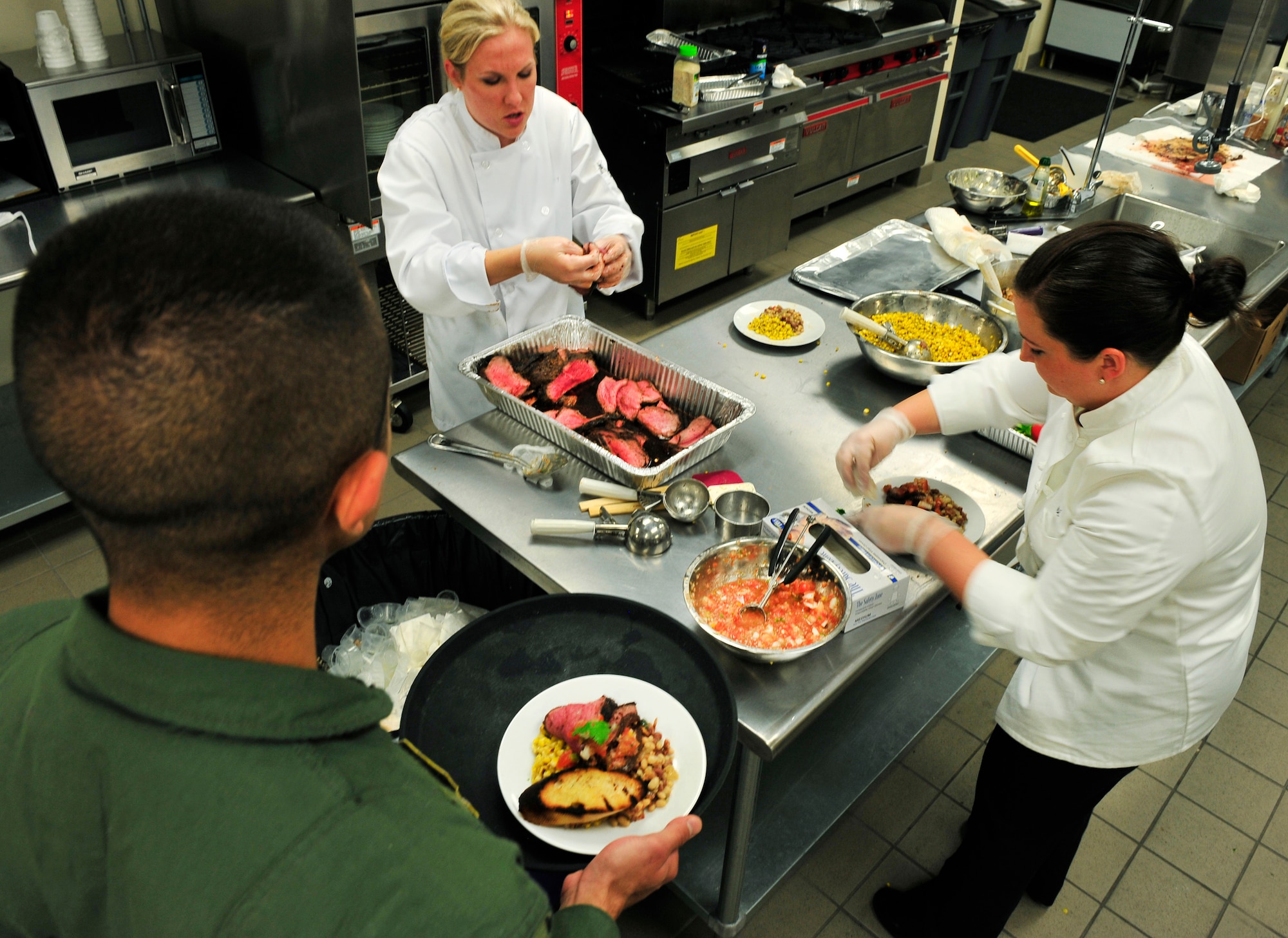 Staff Sgt. Amy Gillilan and Tech. Sgt. Danielle Sloan, flight attendants, artistically place food on plates to be served to 20 people on Scott Air Force Base, Ill June 29, 2011. Sergeant Gillilan and Sloan will be representing Scott at the 2011 Rodeo in the culinary competition.  In preparation for the event they have been cooking meals with the secret ingredient “beef” for multiple audiences to get feedback and improve the meal. (U.S. Air Force photo/Staff Sgt. Stephenie Wade)