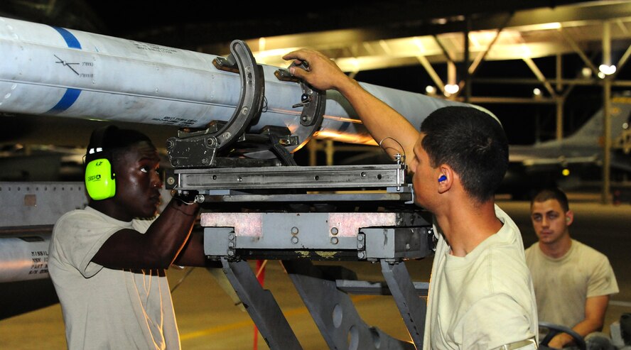 Airman 1st Class William Wattley, Staff Sgt. Jared Rodriguez and Senior Airman Eric Perkins, 79th Aircraft Maintenance Unit crew chiefs, load training weapons to an F-16 fighter jet at Shaw Air Force Base, S.C., July 1, 2011. Flight line personnel often work overtime, holidays and weekends to ensure mission readiness anytime, anywhere. (U.S. Air Force photo/Airman 1st Class Neil D. Warner) (Released)
