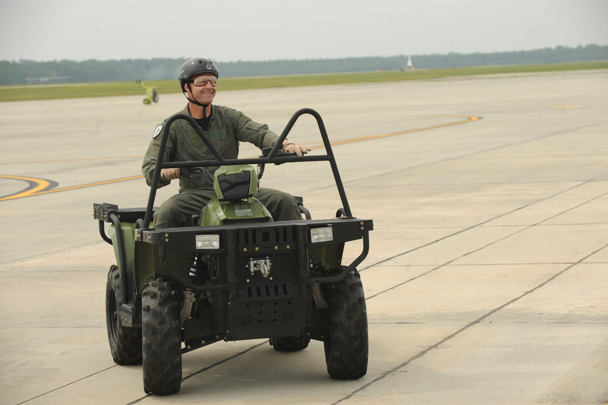 U.S. Air Force Col. Gary Henderson, 23rd Wing commander, rides an all-terrain vehicle toward an HH-60G Pave Hawk during his fini-flight at Moody Air Force Base, Ga., July 12, 2011. Henderson parachuted from HC -130P Combat King and road to the HH-60 for the second part of his flight. (U.S. Air Force photo by Airman 1st Class Paul Francis/Released)