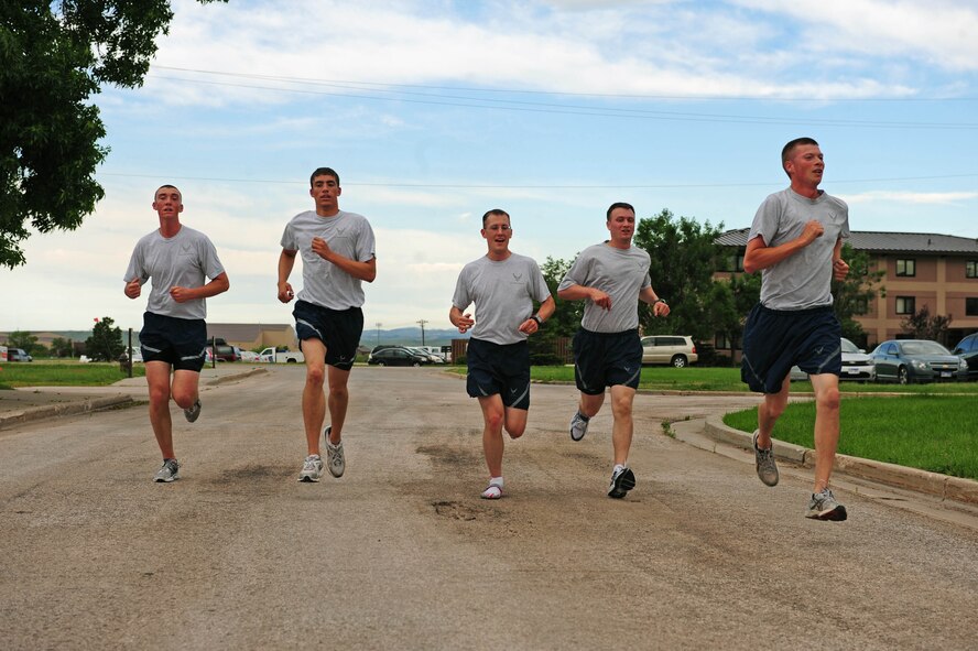 Competing runners, representing each squadron within the 28th Mission Support Group, complete a race together as teammates at Ellsworth Air Force Base, S.D., June 30, 2011. Col. Trent Edwards, 28th MSG commander, organized this Warrior Run to promote safety and wellness before the Fourth of July weekend. (U.S. Air Force photo/Airman Alystria Maurer)