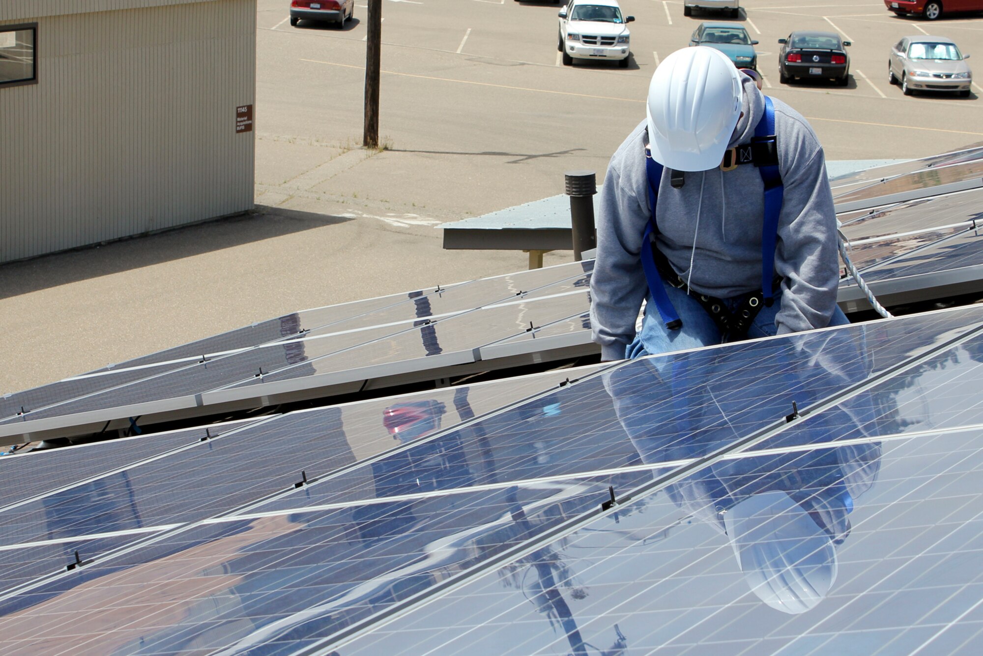 VANDENBERG AIR FORCE BASE, Calif. – A contractor works to install solar panels to a building on base here Monday July 11, 2011.  This project marks the initial push for Vandenberg to become compliant with the Energy Policy Act of 2005, which requires federal agencies to reduce energy intensity 30 percent by 2015.  (U.S. Air Force photo/Jennifer Green-Lanchoney)