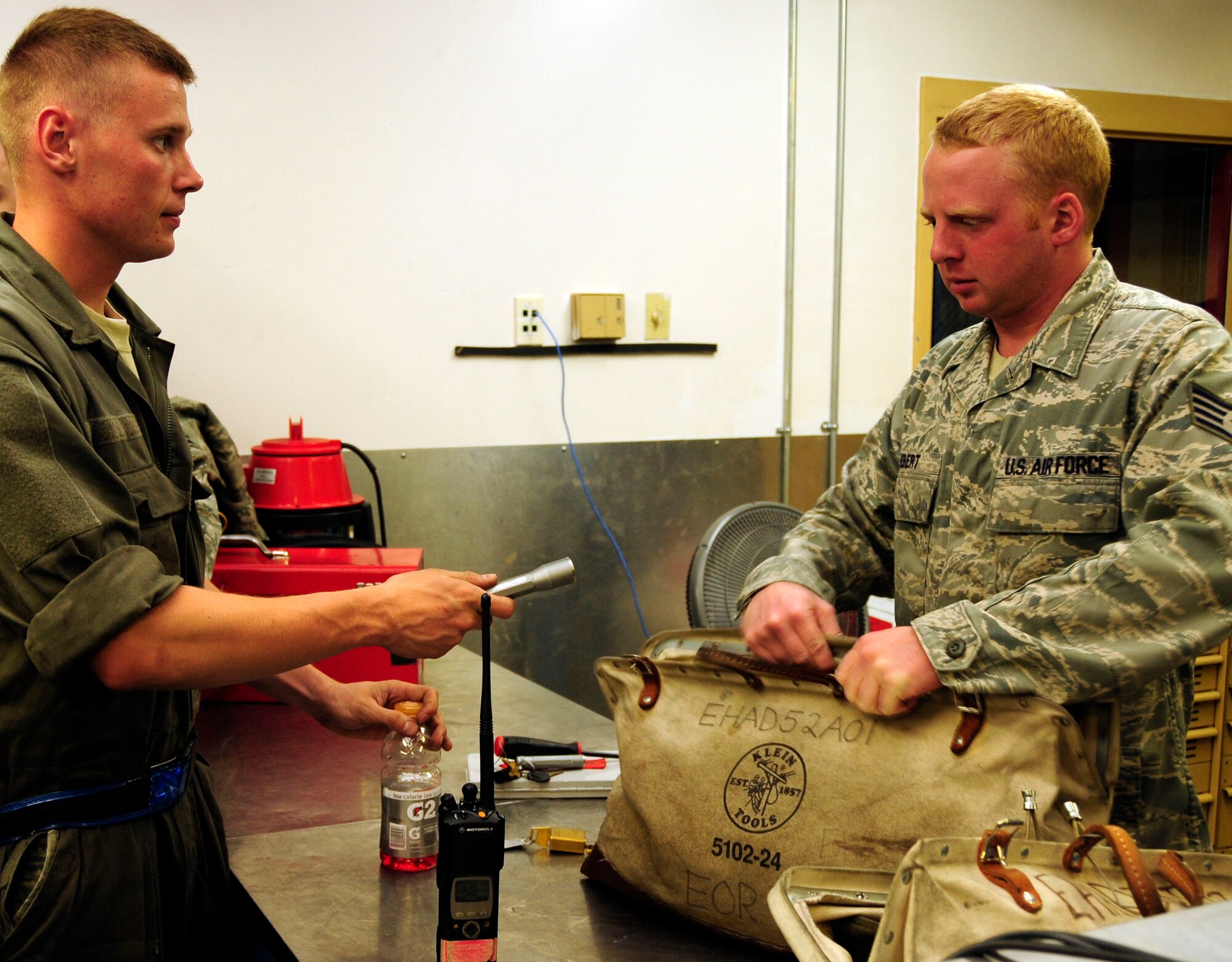 Senior Airman Aleksandr Dolgikh turns in a flashlight along with the rest of his tools to Staff Sgt. Michel Hebert June 28, 2011, Eielson Air Force Base, Alaska. Tools are checked out at the beginning and returned at the end of every shift to be logged into a computer database, ensuring that no tool is left unaccounted for. Airman Dolgikh is a crew chief assigned to the 18th Aircraft Maintenance Unit. Sergeant Michel Hebert is assigned to the 18th AMU supply section. (U.S. Air Force photo/Senior Airman Rachelle Coleman)