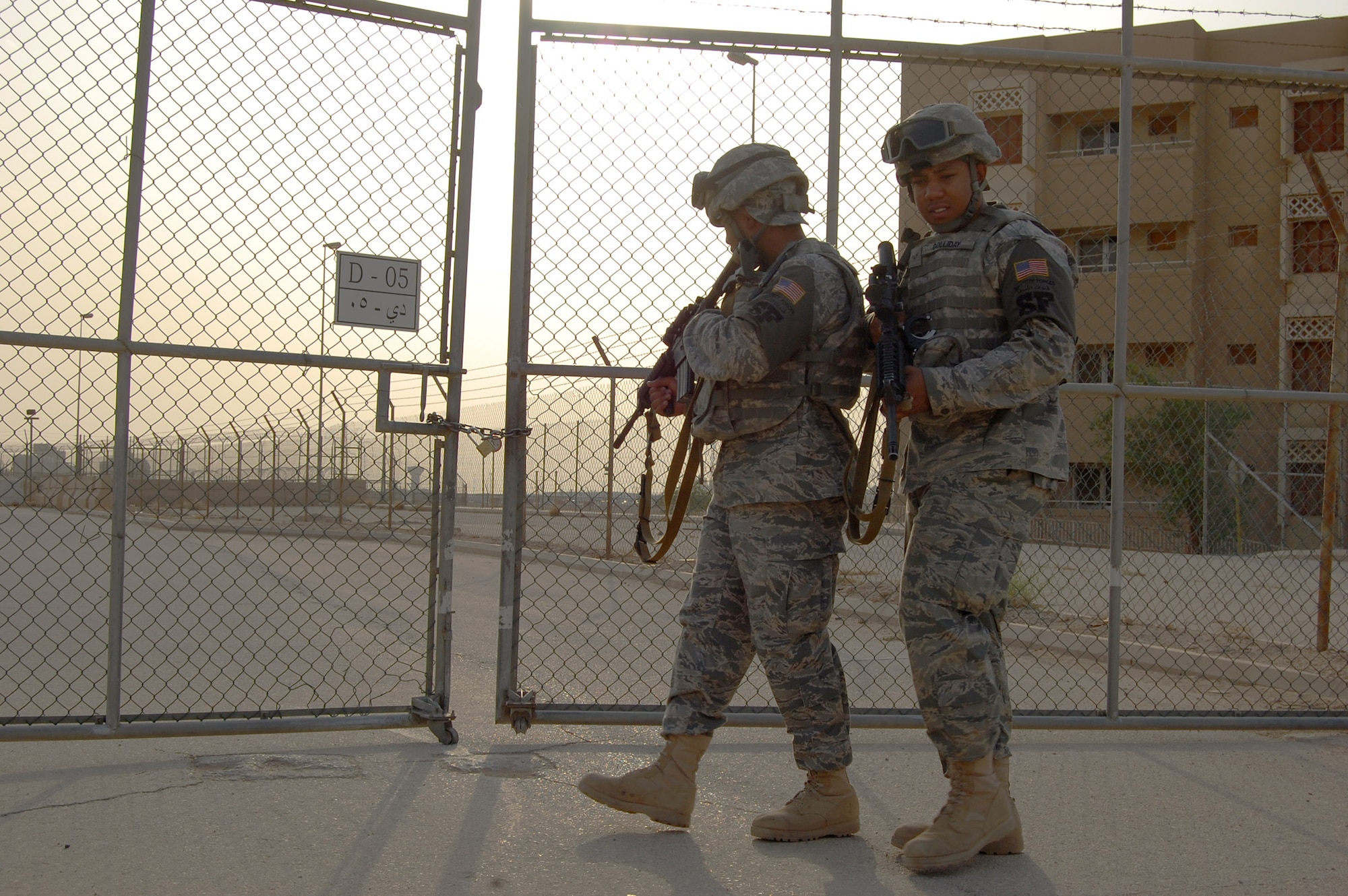 Senior Airman Charles Anderson-Goodman and Airman 1st Class Reginald Golliday, 64th Expeditionary Security Forces Squadron, check a gate at a deployed location in Southwest Asia, July 13. The Airmen are the first two to deploy from a team of Security Forces members attacked, March 2, on a bus at the airport in Frankfurt, Germany. Two teammates were killed and two were injured in the attack. Both Airmen are deployed from the 48th Security Forces Squadron, Royal Air Force Lakenheath, England. (U.S. Air Force photo/Airman 1st Class Timothy A. Genders)