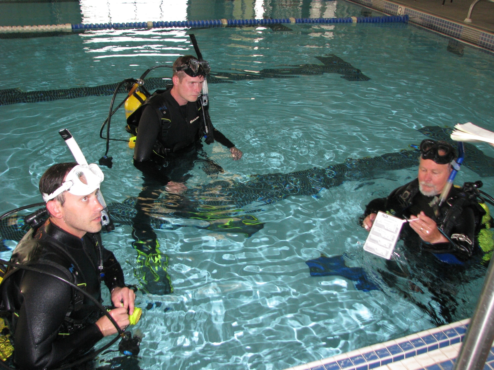 Scuba students Dan Betcovic (sporting white mask) and Joseph Reno (center) listen to last-minute instructions from dive instructor Fred Brown before trying out their new diving skills. (Air Force photo by Diane Betzler)
