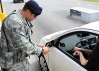 U.S. Air Force Staff Sgt. Adam Sacchetti, 20th Security Forces Squardon patrolman, checks identification cards at the front gate at Shaw Air Force Base, S.C., to make sure everyone has the correct credentials to get onto base July 12, 2011. The 20th SFS provide and enforce protection for Airmen of Shaw and its assets. (U.S. Air Force photo/Airman 1st Class Tabatha L. Duarte) (Released) 