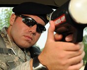 U.S. Air Force Staff Sgt. Adam Sacchetti, 20th Security Forces Squadron patrolman, aims the radar gun to enforce speeding regulations at Shaw Air Force Base, S.C., July 12, 2011. The 20th SFS provide and enforce protection for Airmen of Shaw and its assets.  (U.S. Air Force photo/Airman 1st Class Tabatha L. Duarte) (Released) 