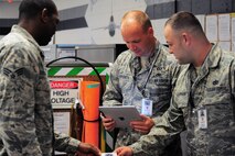 SHAW AIR FORCE BASE, S.C. -- Tech. Sgt. Dustin Hayden and Staff Sgt. Anthony Altomare, 20th Fighter Wing ground safety technicians, hand Senior Airman James McLean, 20th Component Maintenance Squadron avianonics technician, a buisiness card after a safety inspection at the 20th CMS building here. Hayden and Altomare are the Warriors of the Week for the week of July 11 through 15. (U.S. Air Force photo/ Airman 1st Class Daniel Phelps)