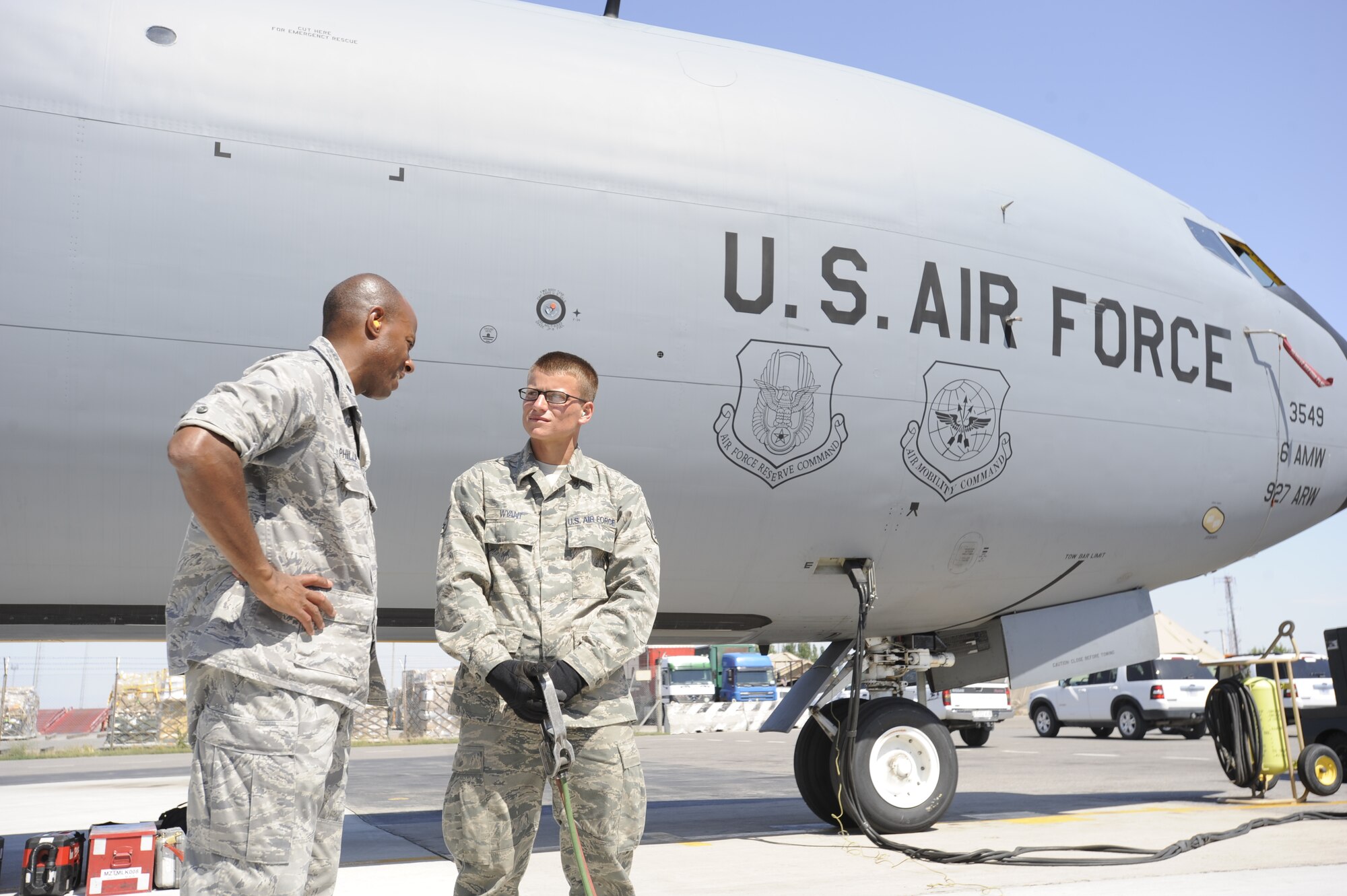 Senior Airman Chantz Wyant (r) talks with Lt. Col. Will Phillips III as he refuels a KC-135 Stratotanker at the Transit Center at Manas, Kyrgyzstan, July 11. While refueling this KC-135 Wyant achieved a deployment milestone by pumping more than 5 million gallons of JP8 during his time at the Transit Center. Wyant is a 376th Expeditionary Logistics Readiness Squadron fuels distribution operator deployed here from McConnell Air Force Base, Kan. Phillips is the 376th ELRS commander deployed here from Joint Base Lewis McChord, Wash. (U.S. Air Force photo/Tech. Sgt. Tammie Moore)