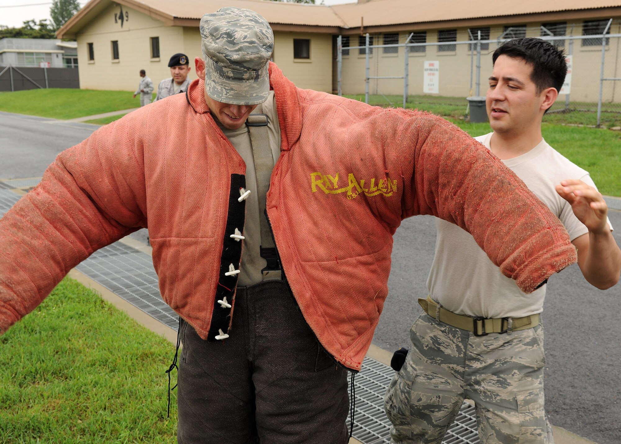 KUNSAN AIR BASE, Republic of Korea -- Tech Sgt. Santiago Bernal, 8th Security Forces Squadron canine handler, assists Senior Airman Christopher Kilbourne, 8th Logistics Readiness Squadron mechanic, in putting on a bite suit here July 11. Bite suits are used in training scenarios with security forces in standoffs and searches. The event was done to create unity among squadrons and encourage camaraderie. (U.S. Air Force photo/Senior Airman Ciara Wymbs) 