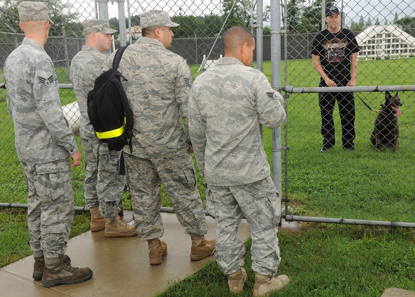KUNSAN AIR BASE, Republic of Korea -- Staff Sgt. Joshua Fehringer, 8th Security Forces Squadron canine handler, gives information about dog handling and training to members from the 8th Logistics Readiness Squadron here July 11. These 8th LRS members volunteered to become familiarized with dog training as part of a camaraderie event held by 8th SFS. (U.S. Air Force photo/Senior Airman Ciara Wymbs)