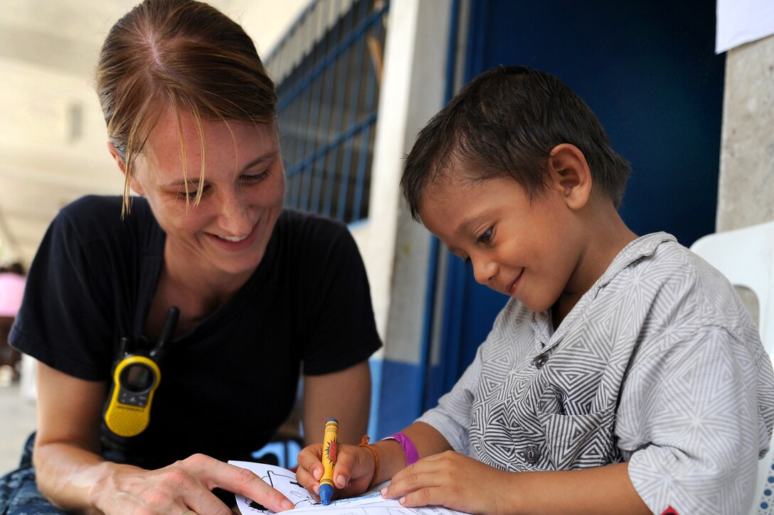 U.S. Navy Lt. Karen Gorlewski watches a child color at the Santa Isabel medical site during Continuing Promise 2011 in Puerto San Jose, Guatemala, July 7, 2011. 